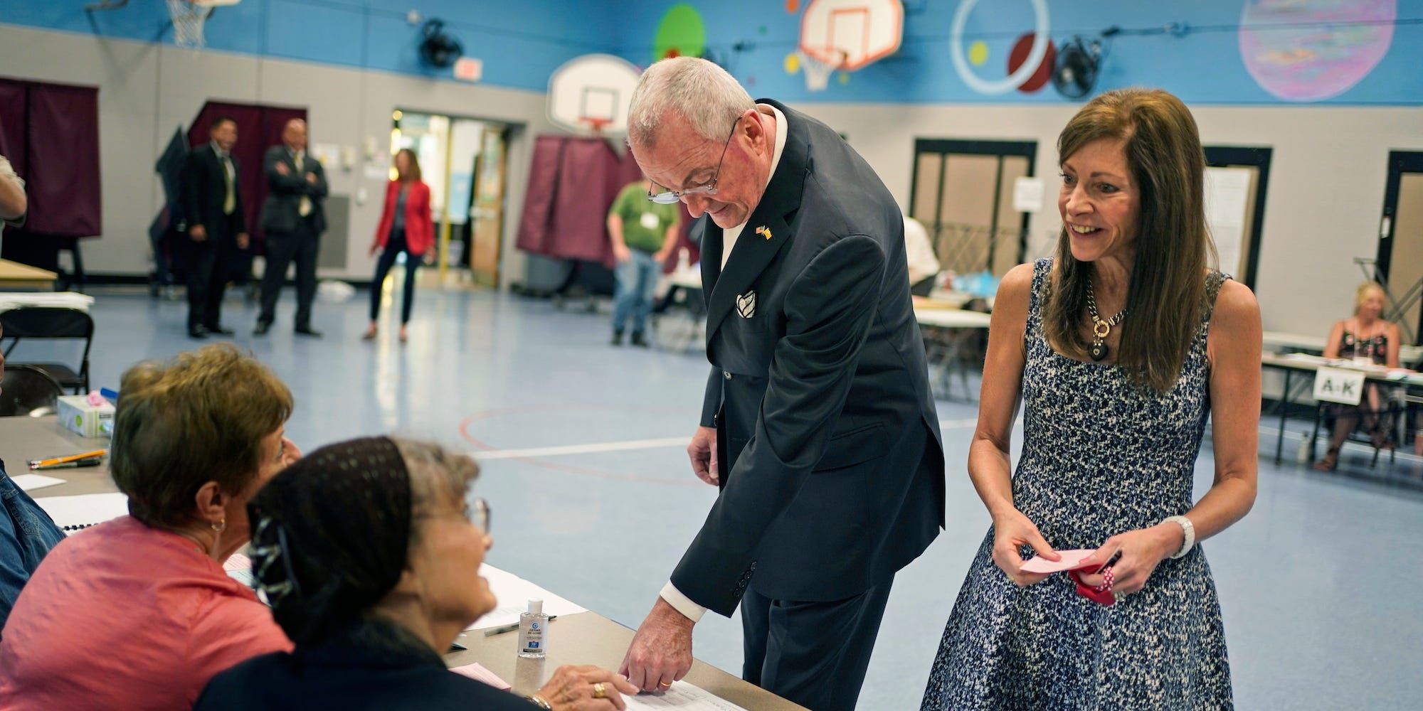 New Jersey Gov. Phil Murphy, second from right, and his wife Tammy Murphy talk with poll workers before voting in Red Bank, N.J., Tuesday, June 8, 2021.