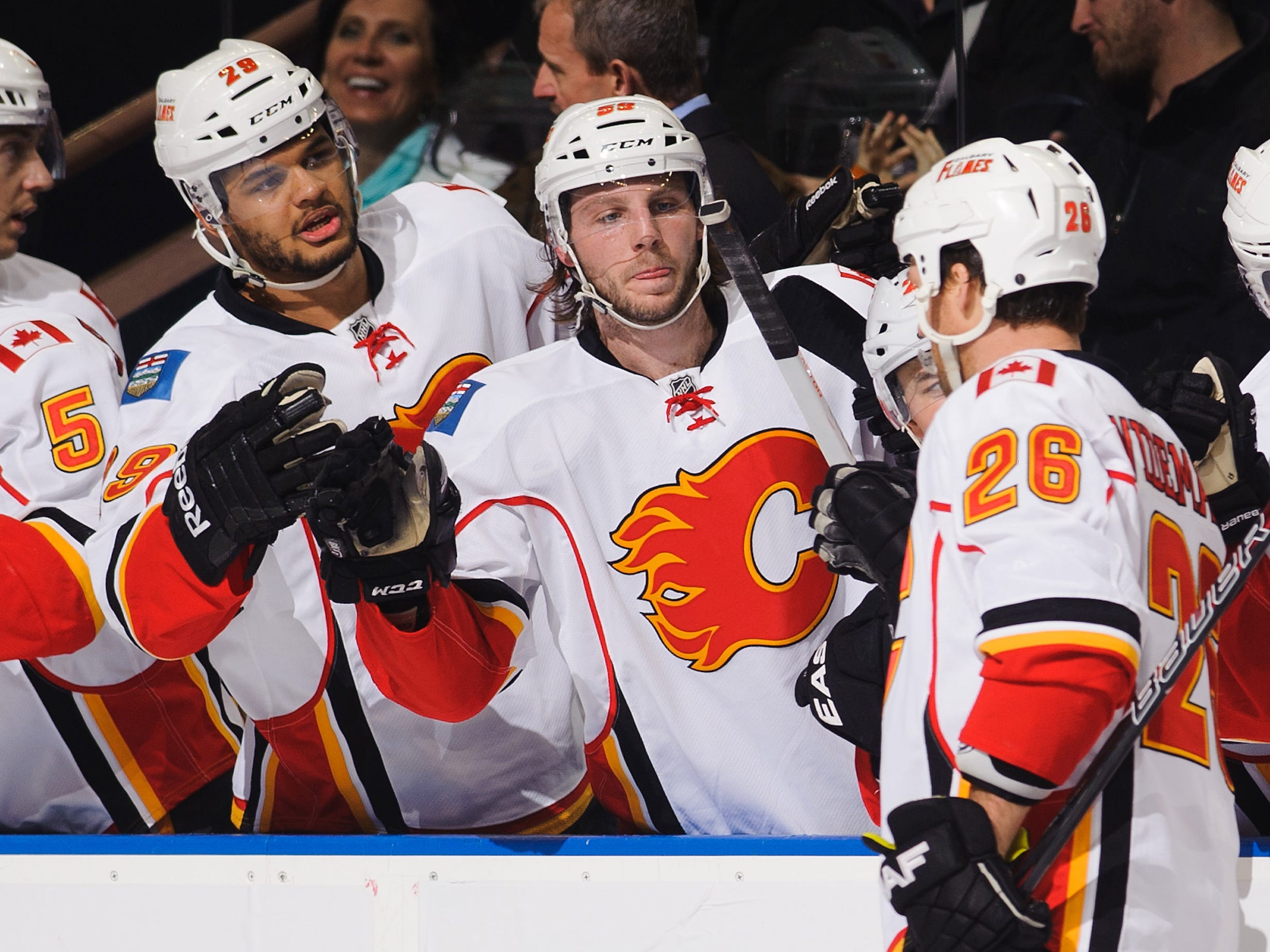 Hockey players slap hands in celebration after a goal.