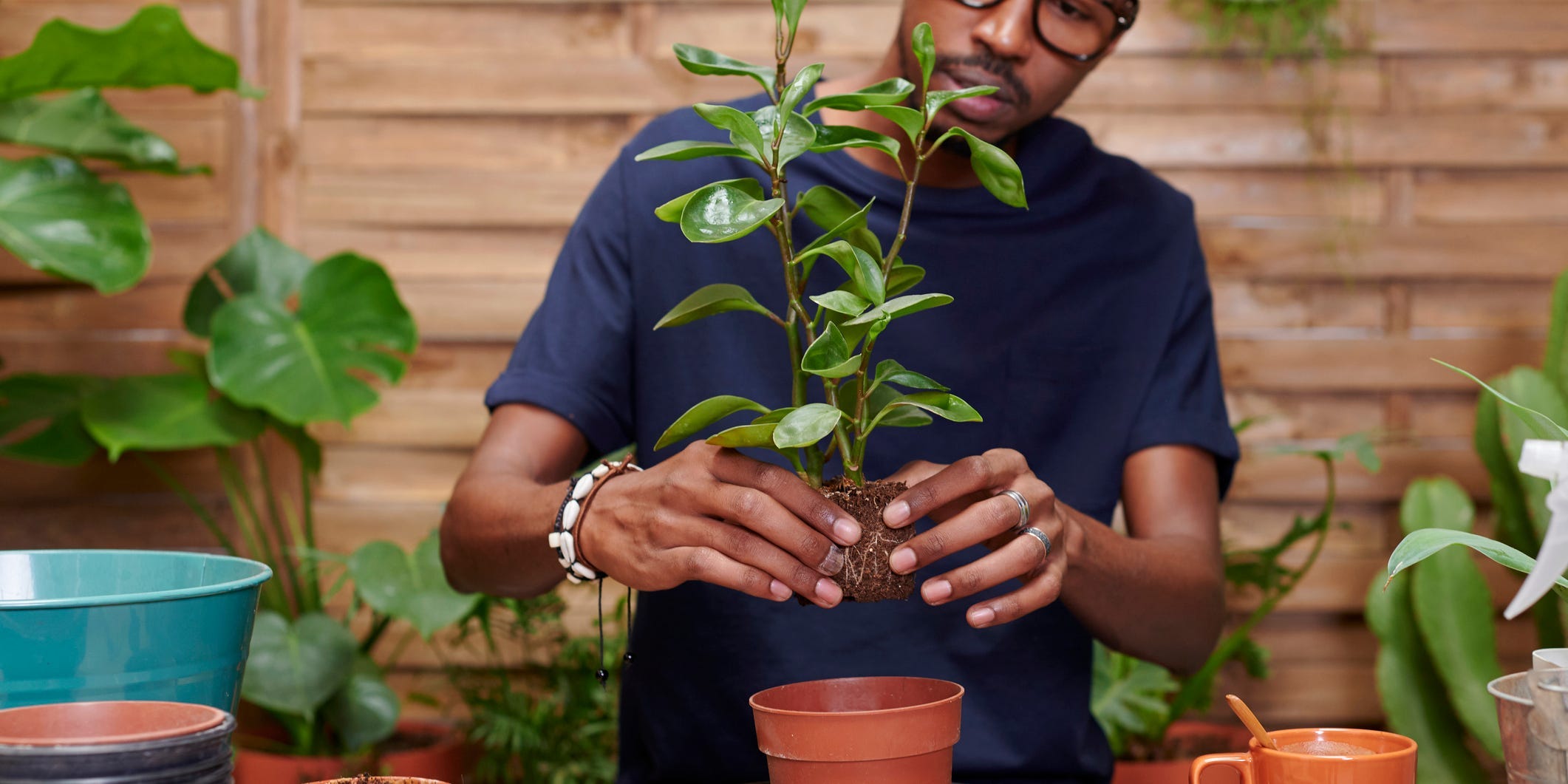 A person about to place a plant into a larger pot