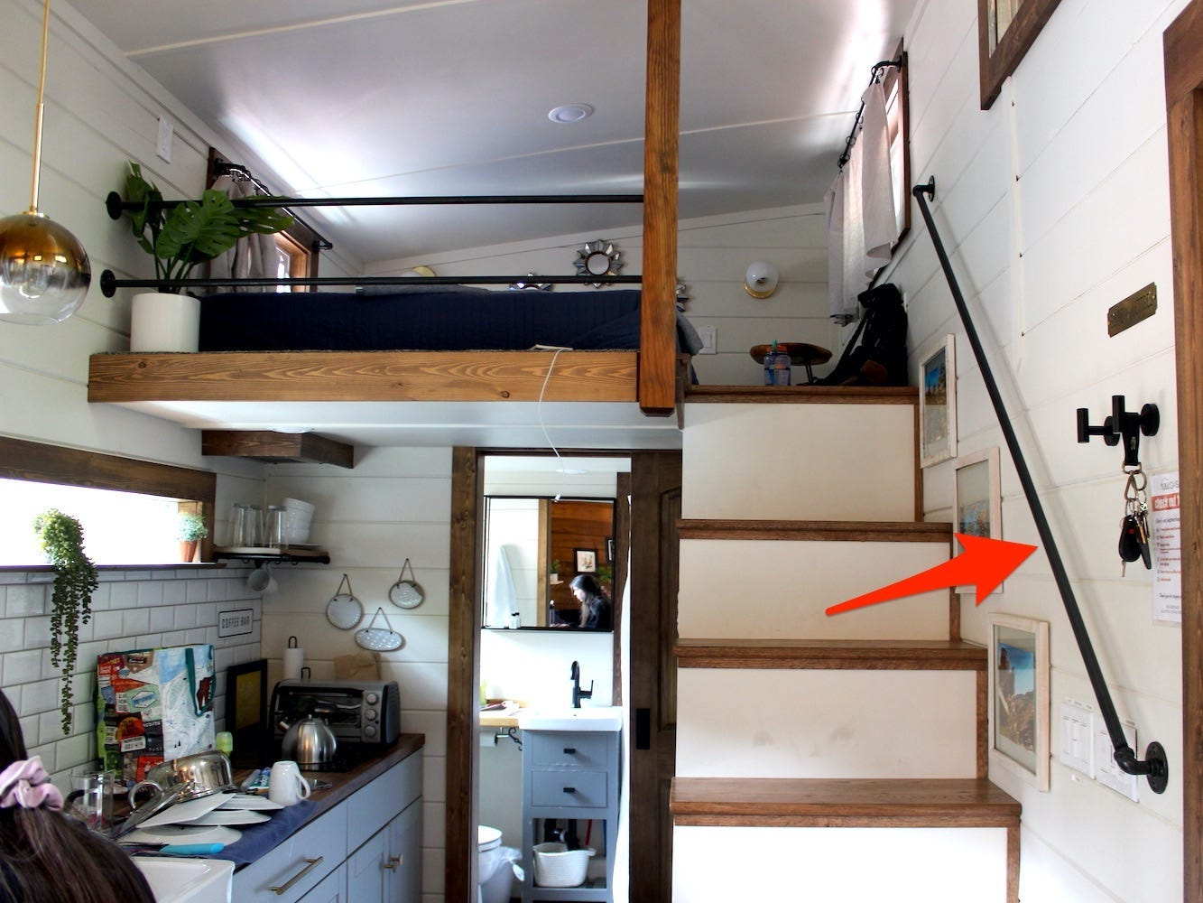 An arrow points to the handrail in the tiny house.