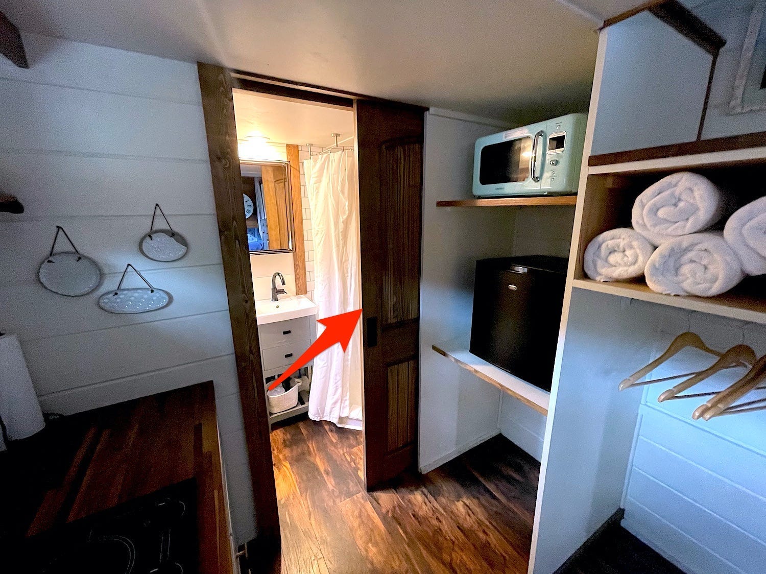 An arrow points to the pocket door, which separated the bathroom from the rest of the tiny house.