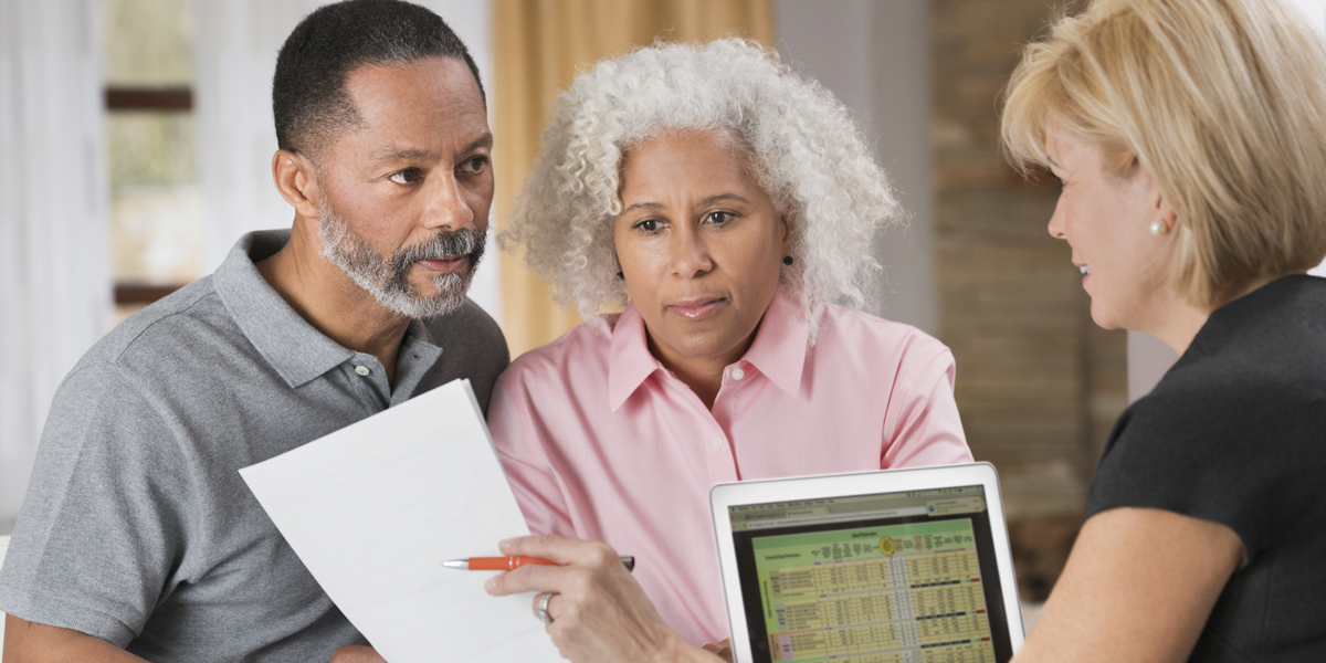 A photo of a couple consulting with a financial planner.