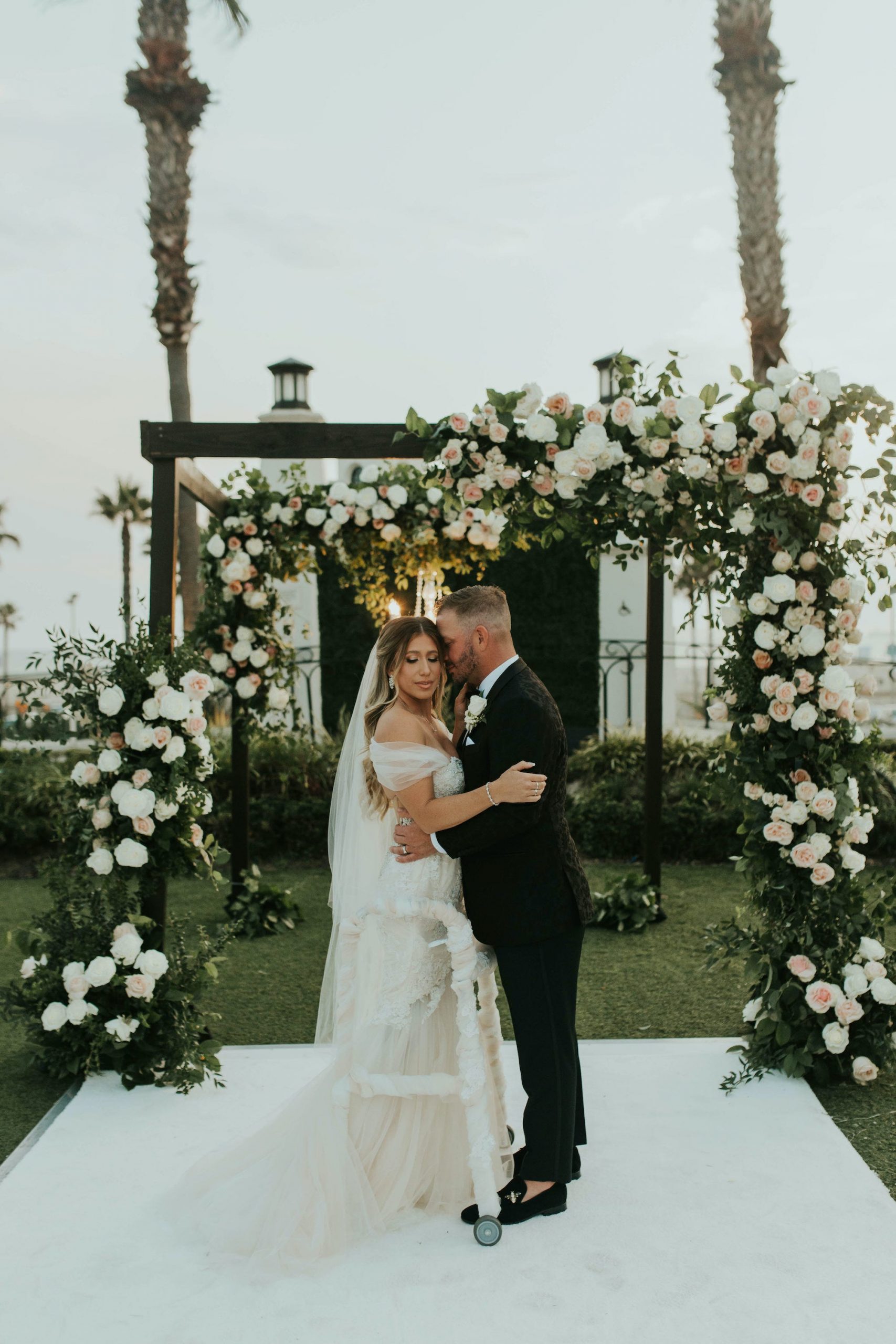 A bride and groom stand at their wedding altar.