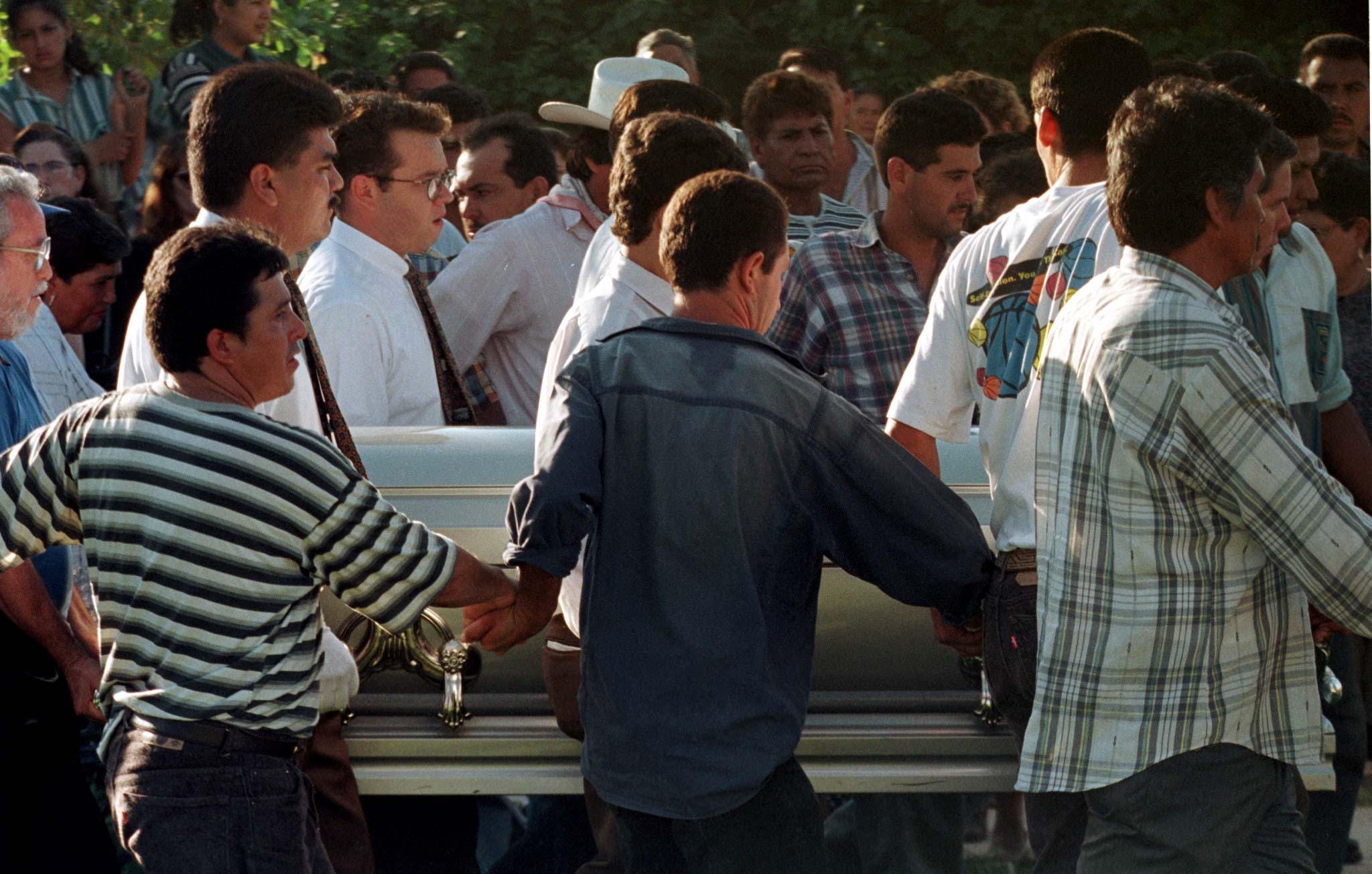 Men are seen carrying a casket.