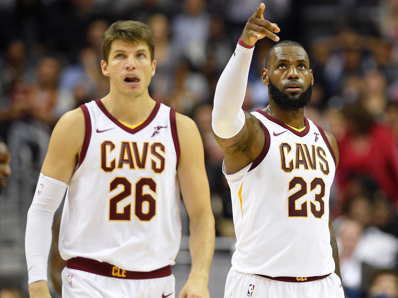 Kyle Korver looks up while standing next to a pointing LeBron James.