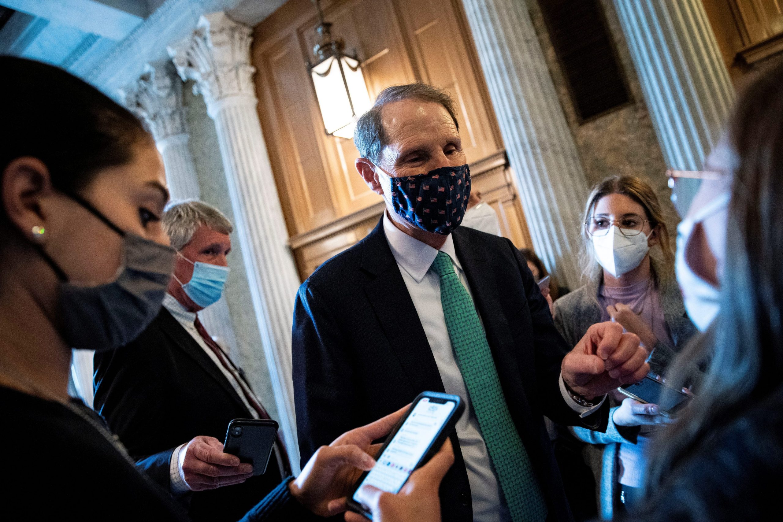 Senator Ron Wyden wears a mask and speaks to reporters in the US Capitol