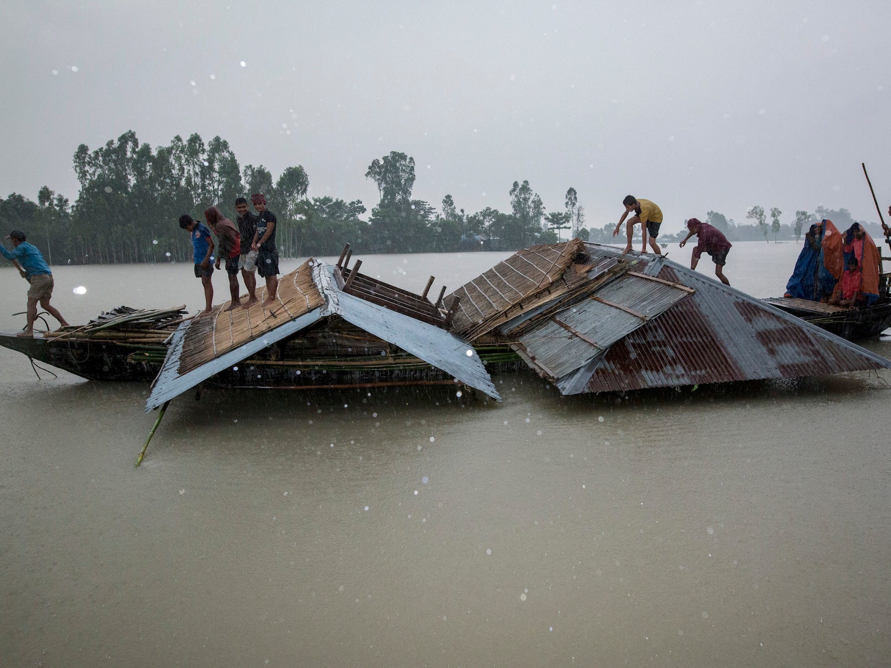 Bangladeshi flood victim man carrying their houses by boat during flood in Kurigram, Bangladesh on July 27, 2019.