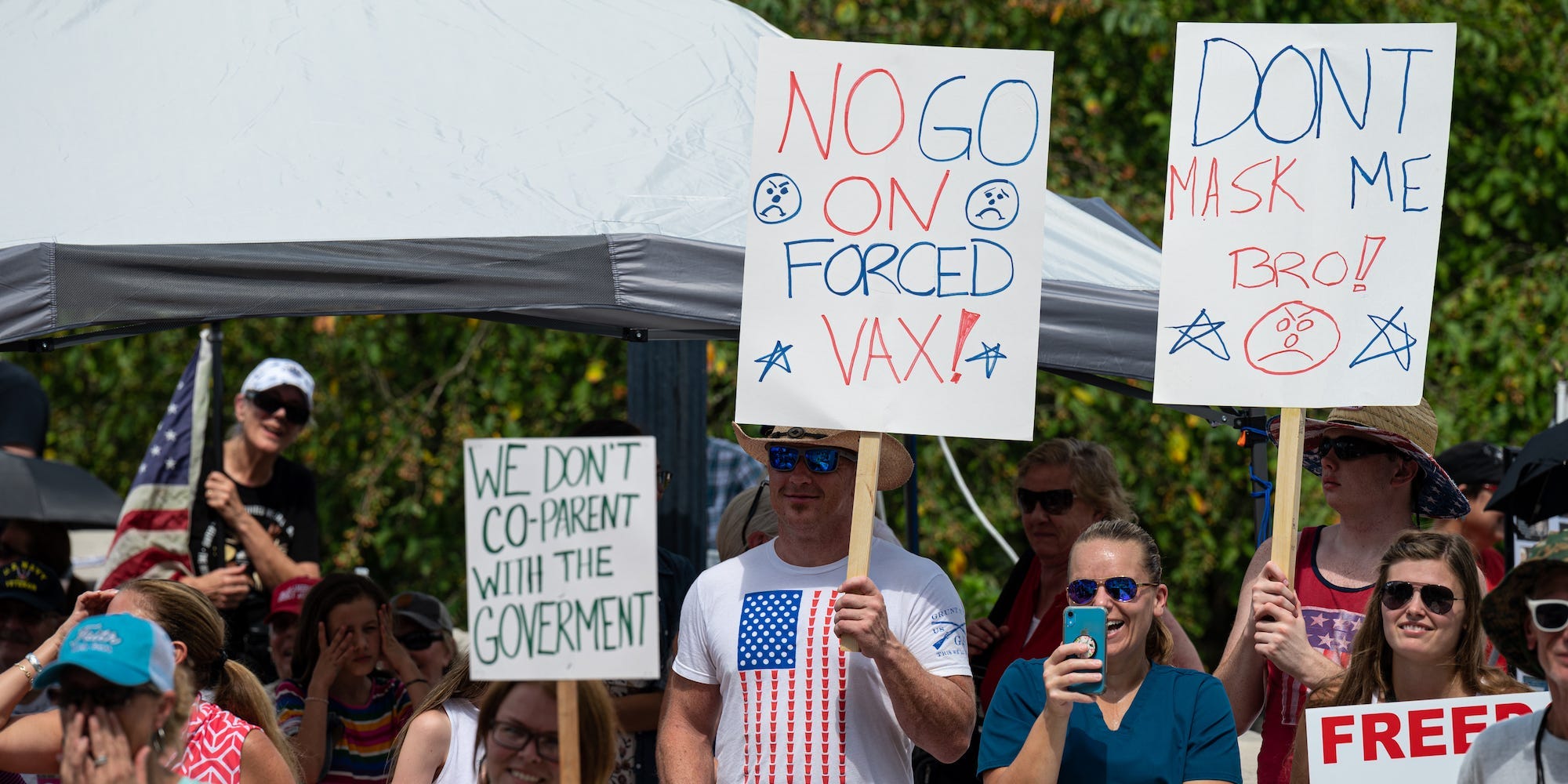 People display signs protesting mask and vaccine mandates during the Kentucky Freedom Rally at the capitol building on August 28, 2021 in Frankfort, Kentucky.