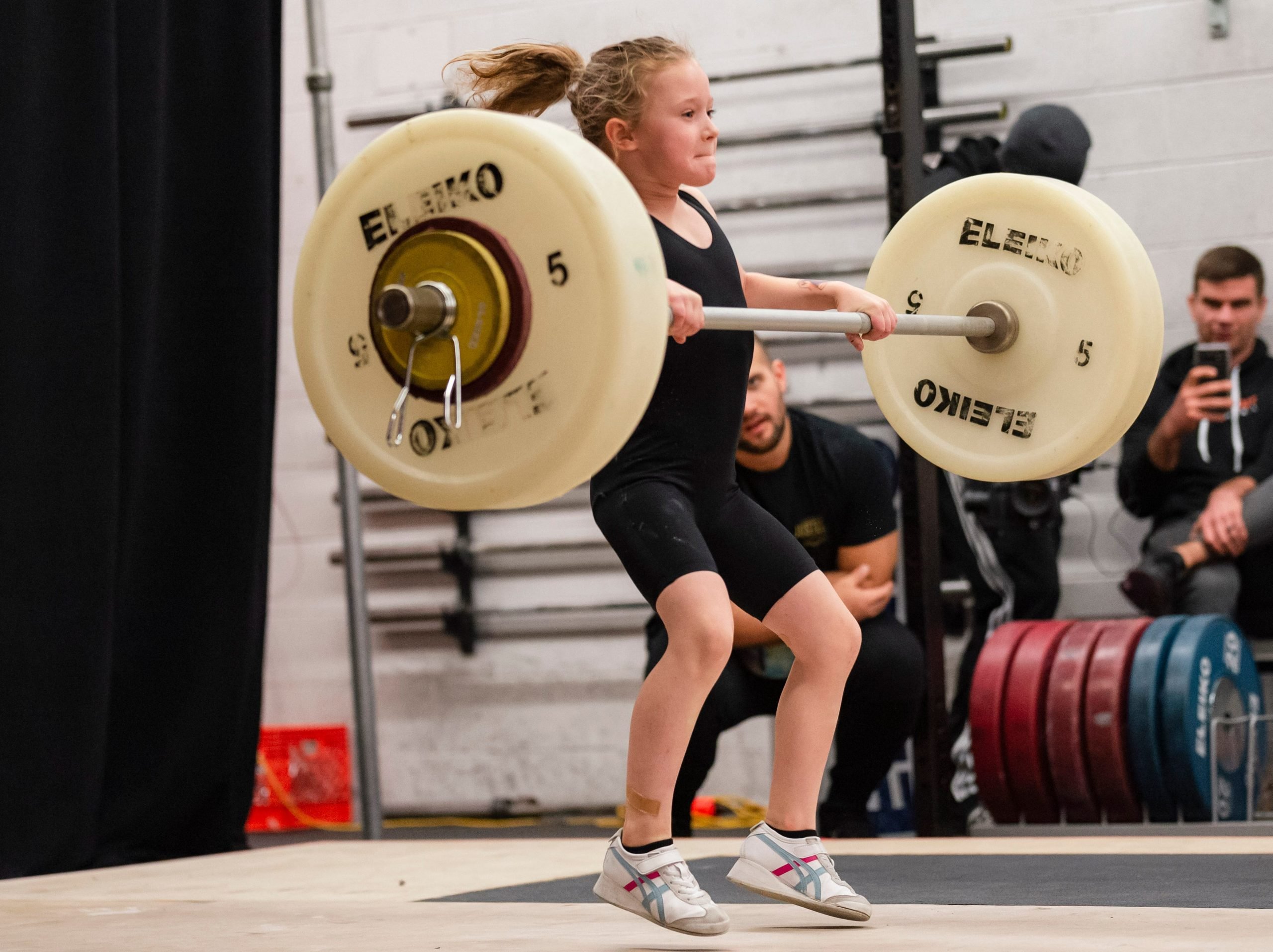 an eight-year-old weightlifter performing an Olympic barbell snatch