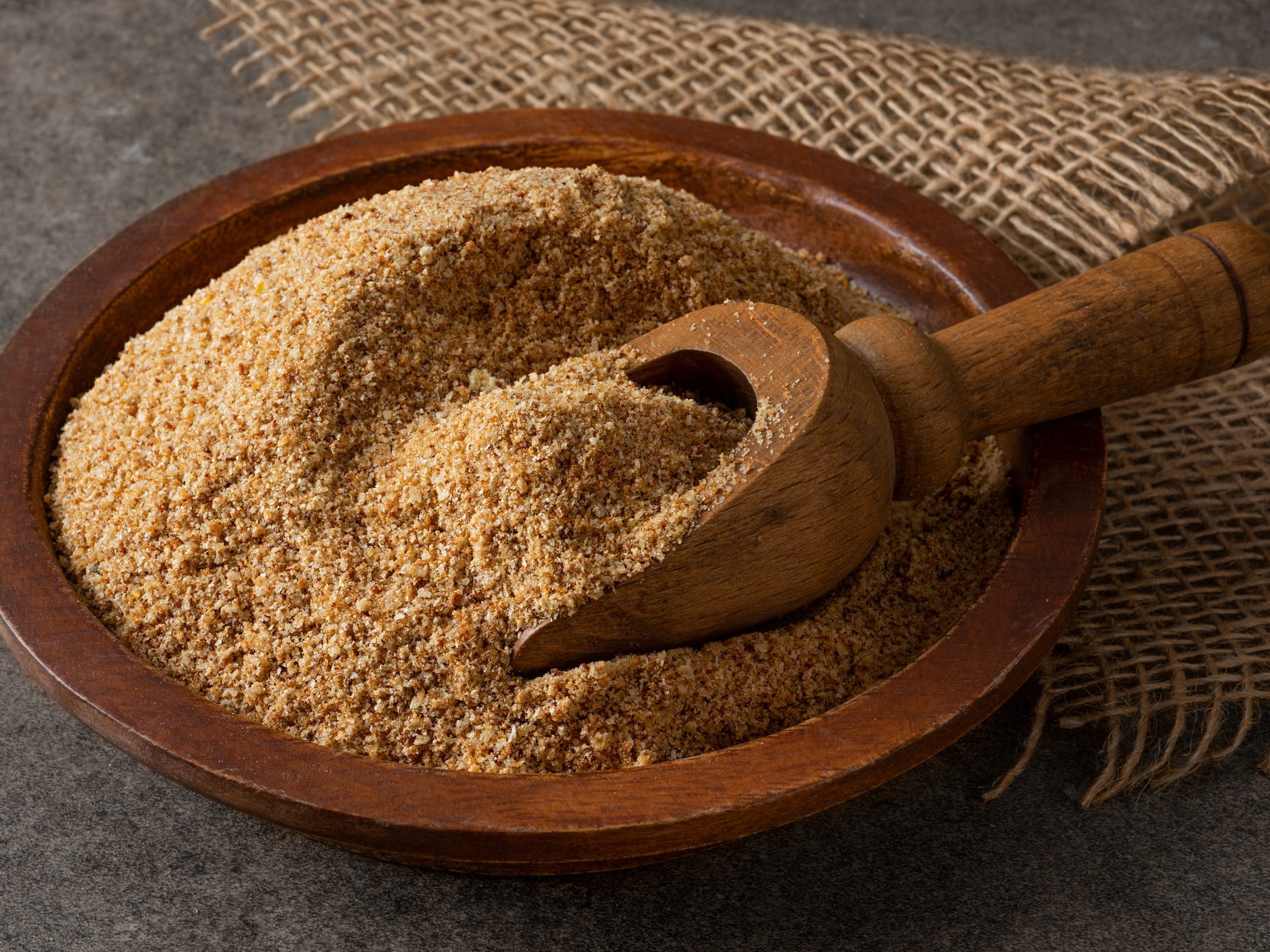 A wooden bowl of whole wheat breadcrumbs.