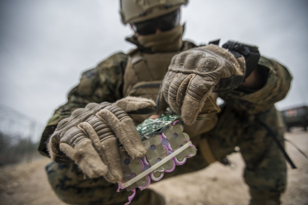 An explosive ordinance disposal Marine working with a simulated IED during a training exercise.