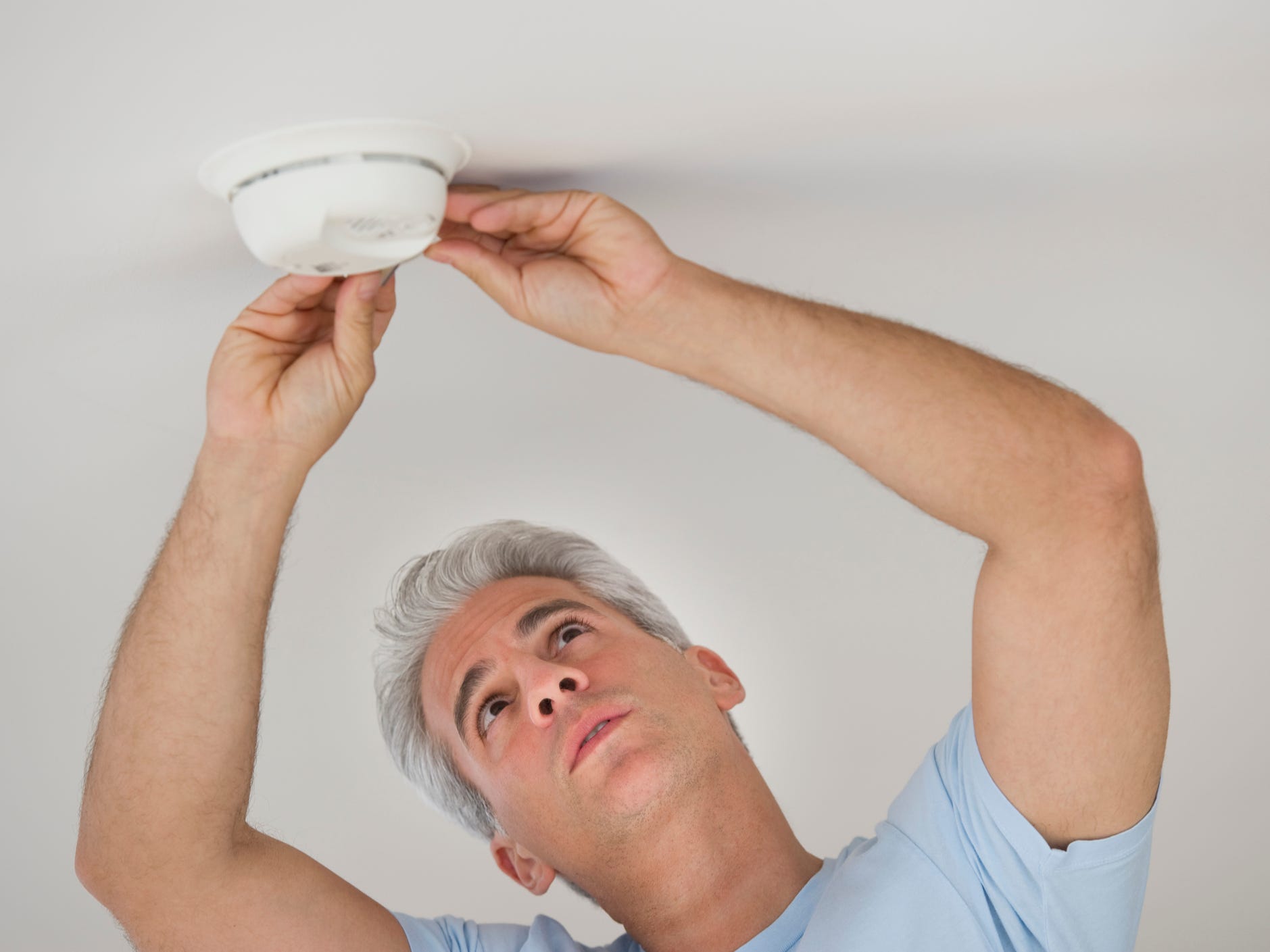 Man testing a smoke detector.