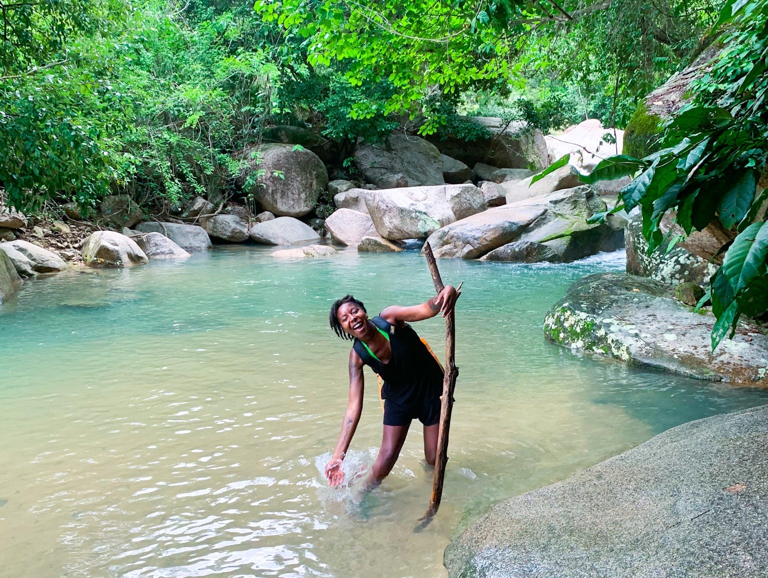 amber wading in water holding a waling stick in mexico