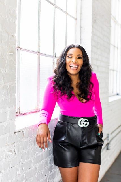 Instagram influencer and marketer Brittany Jack wears a pink shirt and leather shorts