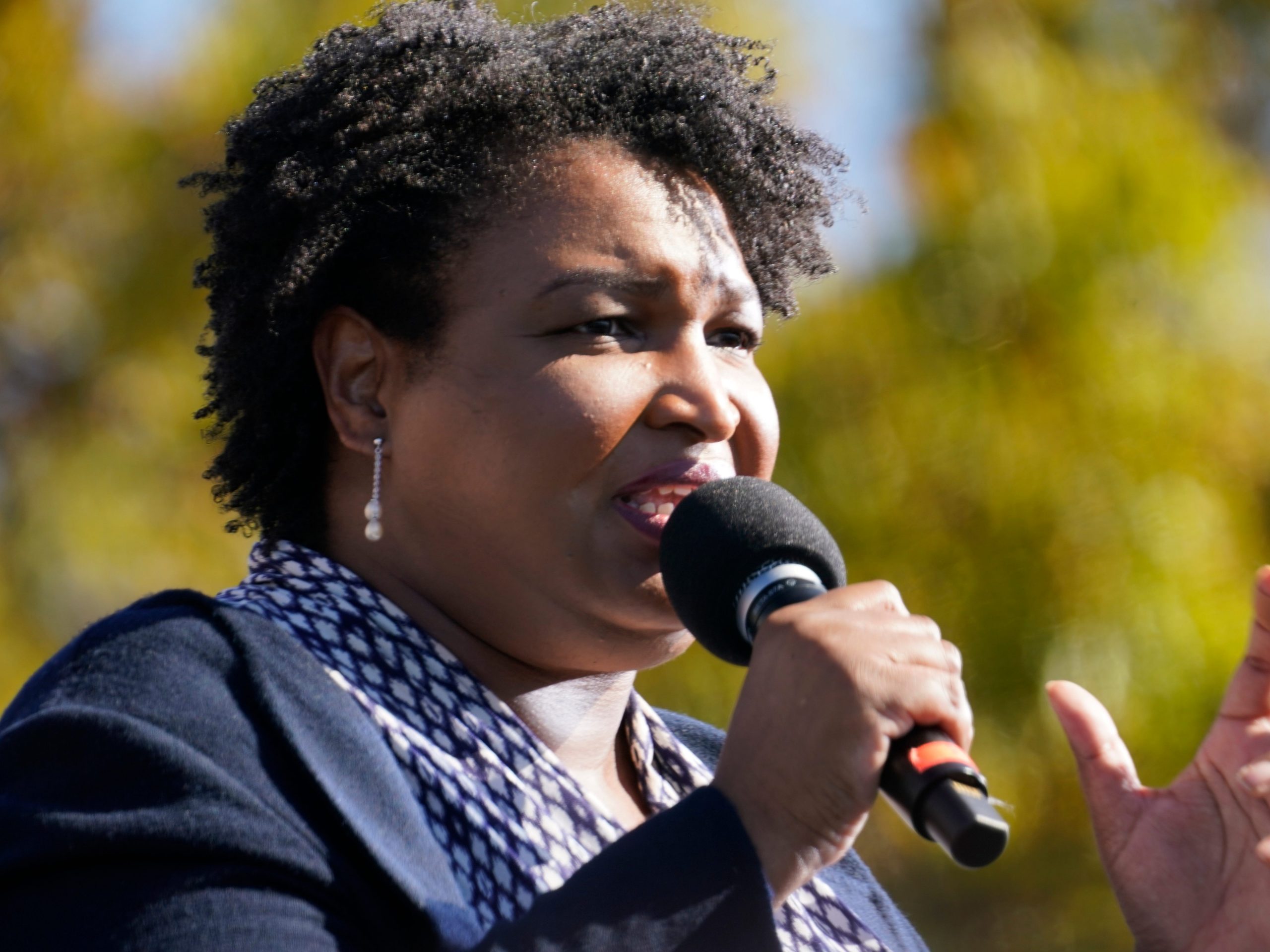 Stacey Abrams speaks into a microphone.