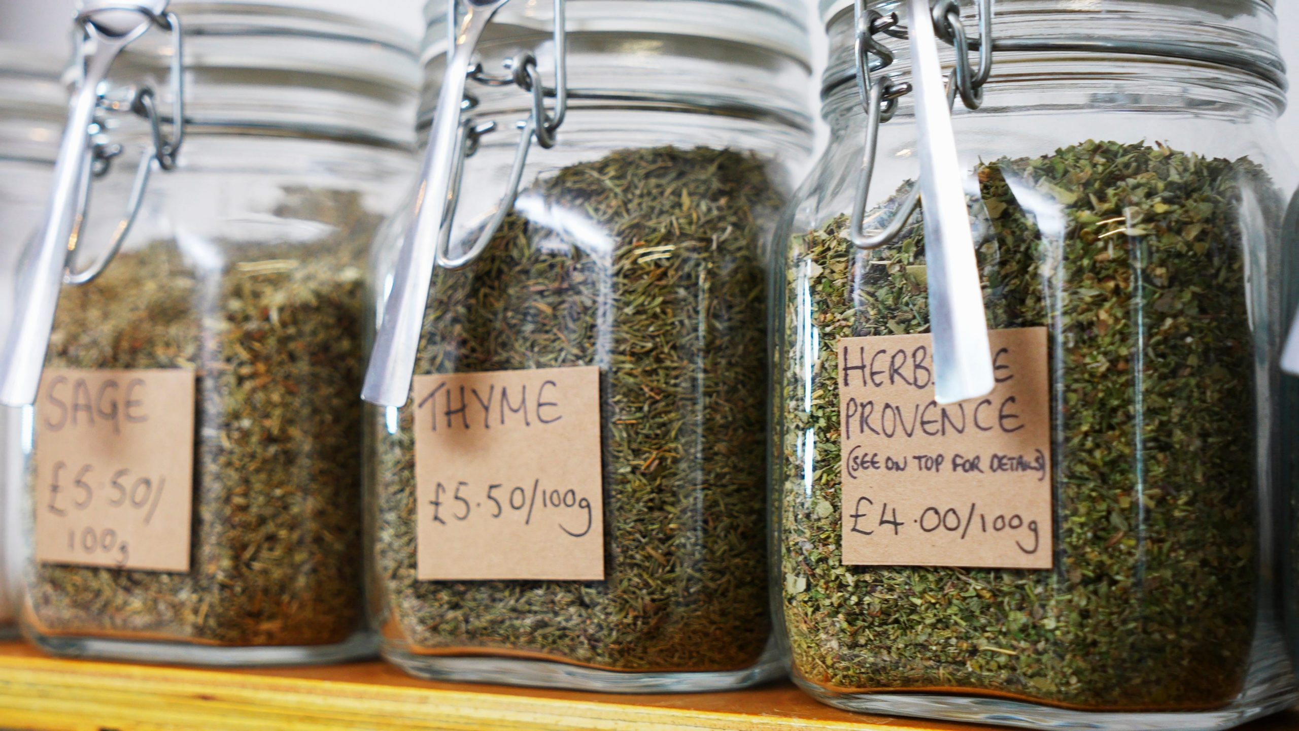 sage, thyme, and herbes de provence in glass jars