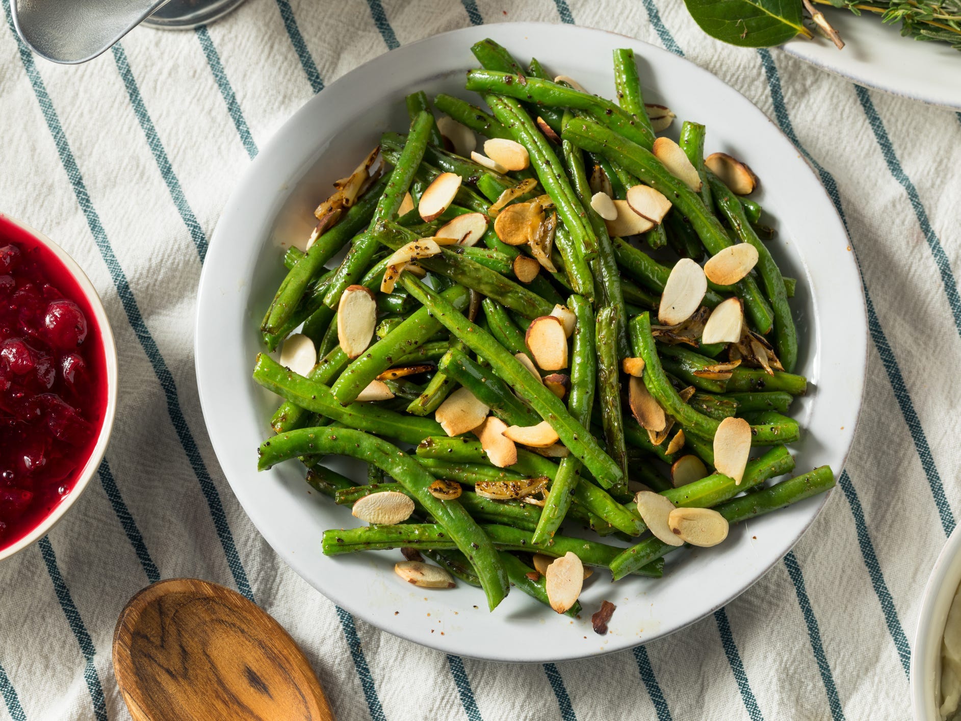 A bowl of green beans topped with toasted almonds