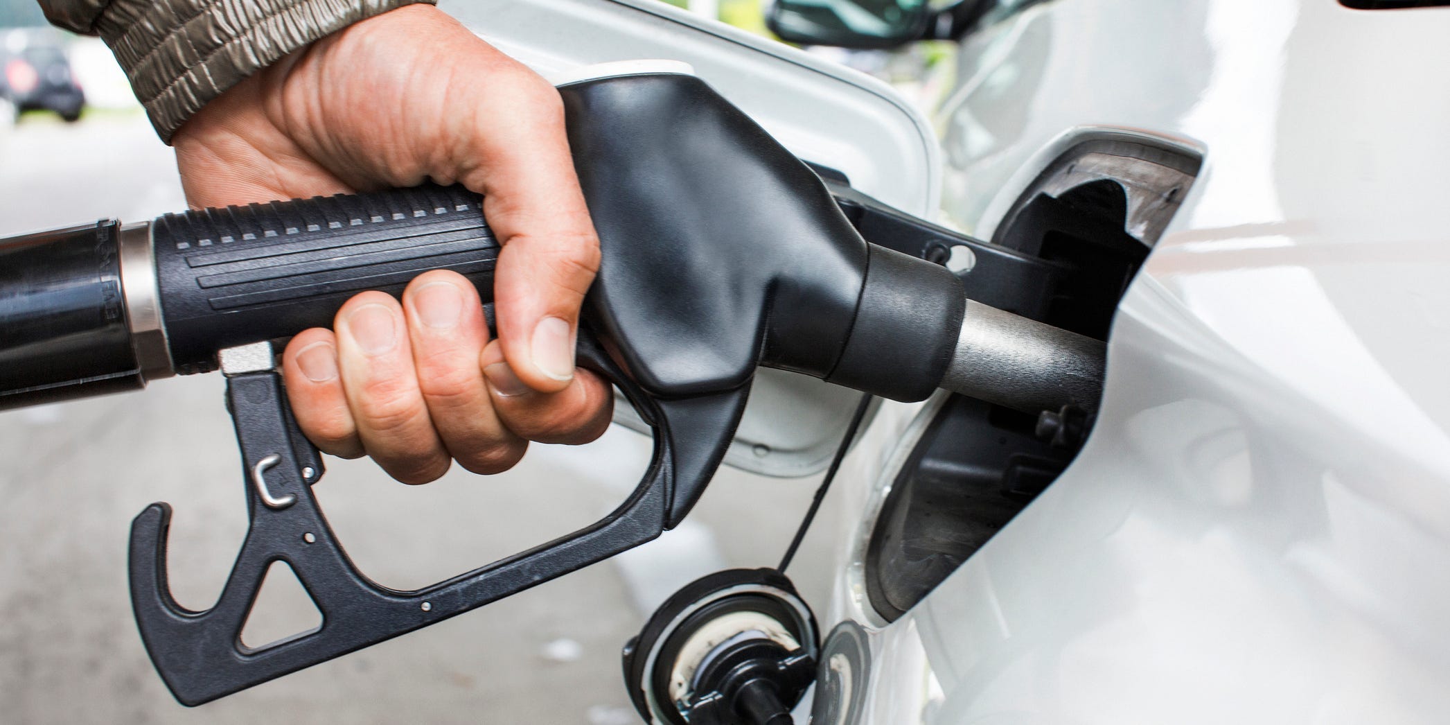 A closeup of a hand pumping gas