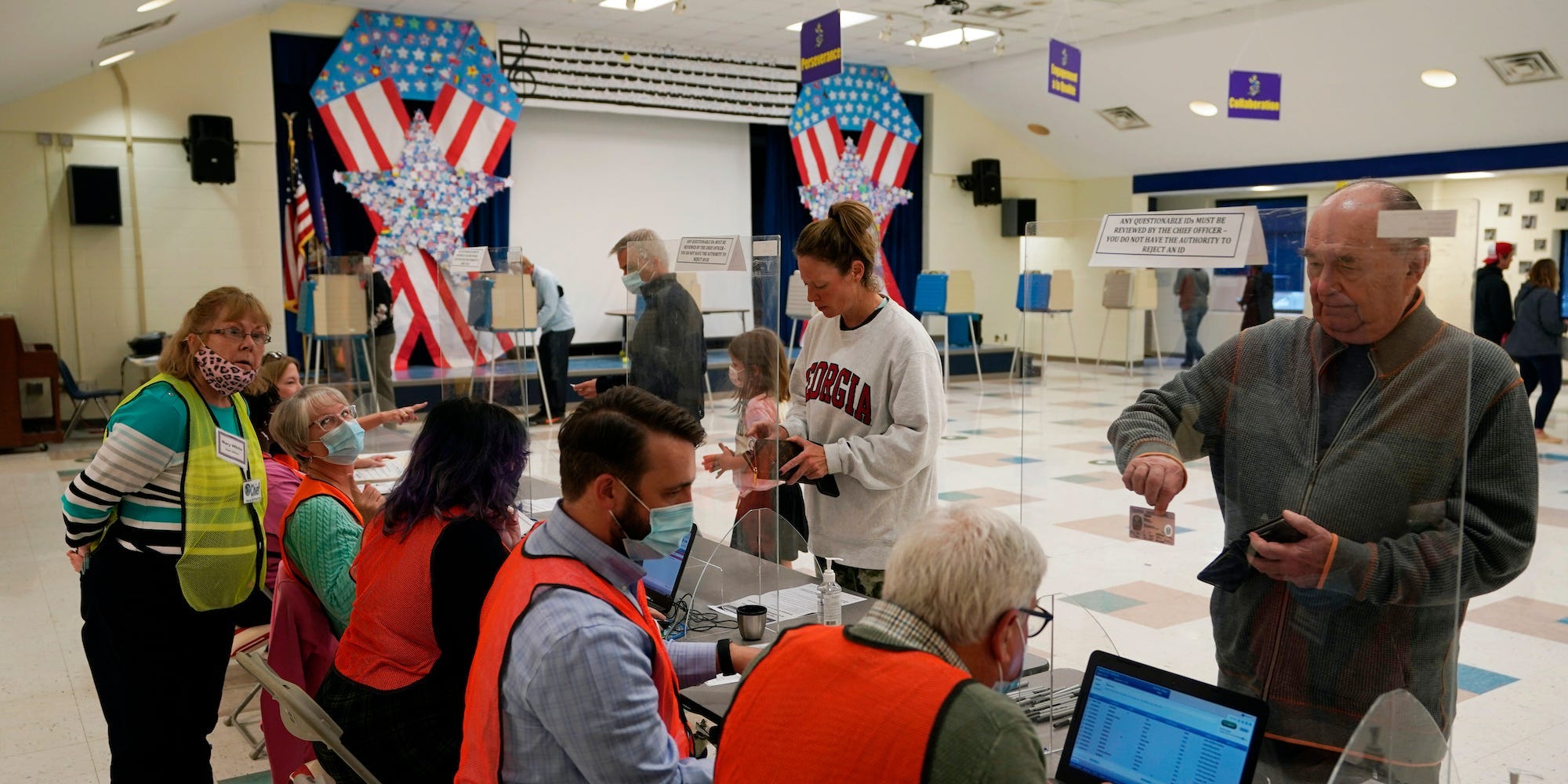 Voters wait in line to check in to vote at a school in Midlothian, Va., Tuesday, Nov. 2, 2021