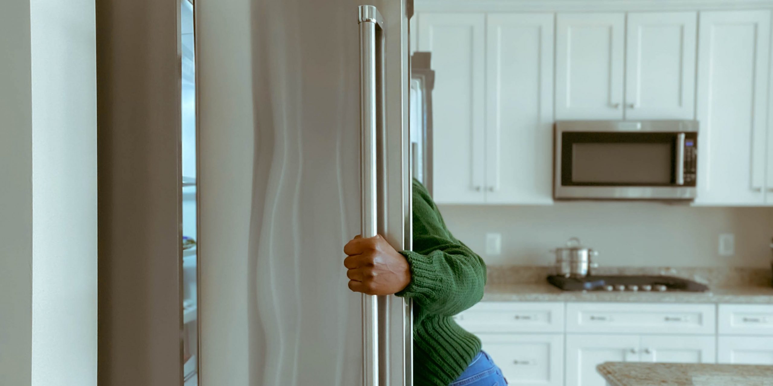 Woman look into a refridgerator.