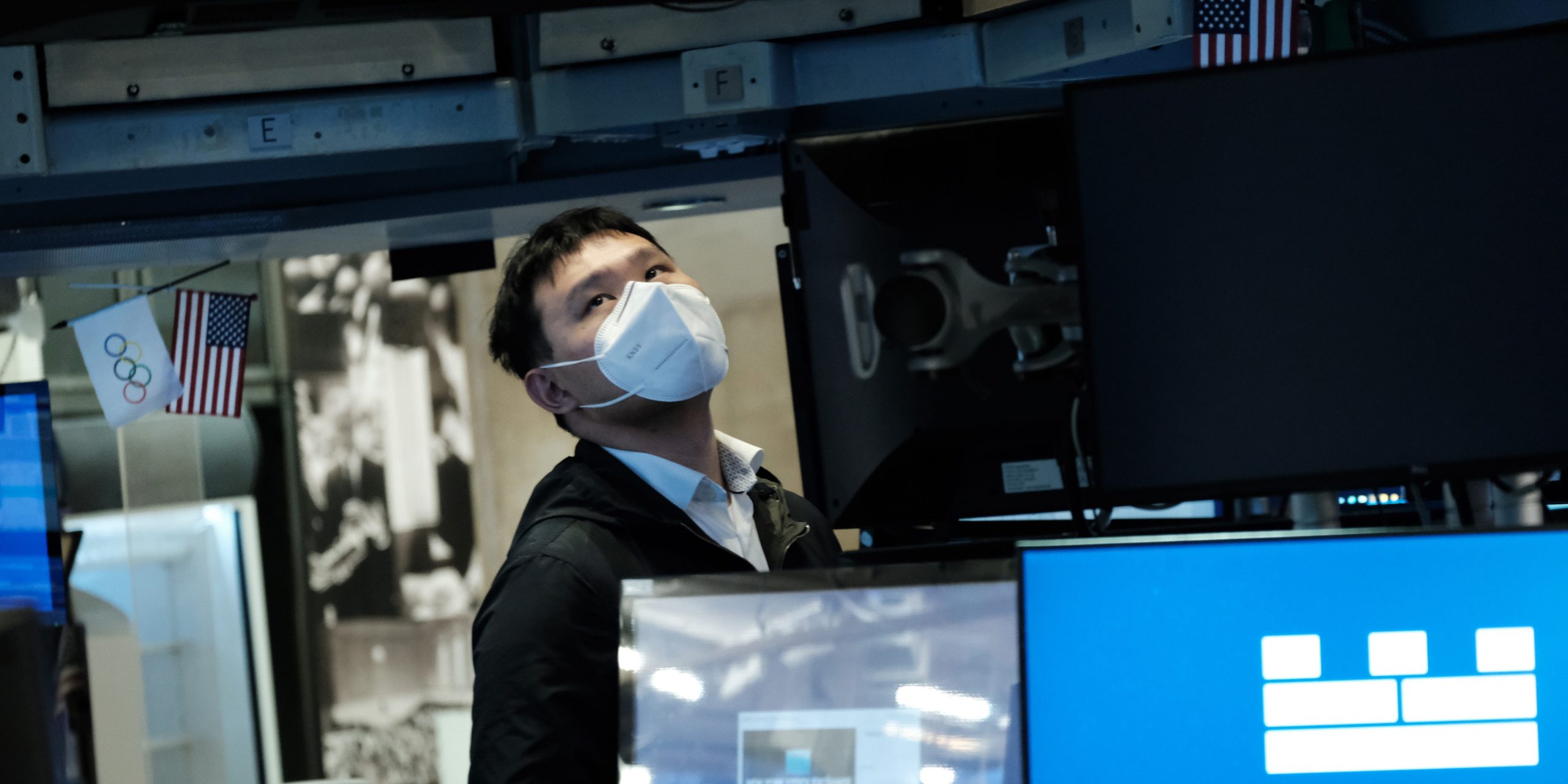 A trader wearing a mask works on the floor of the New York Stock Exchange