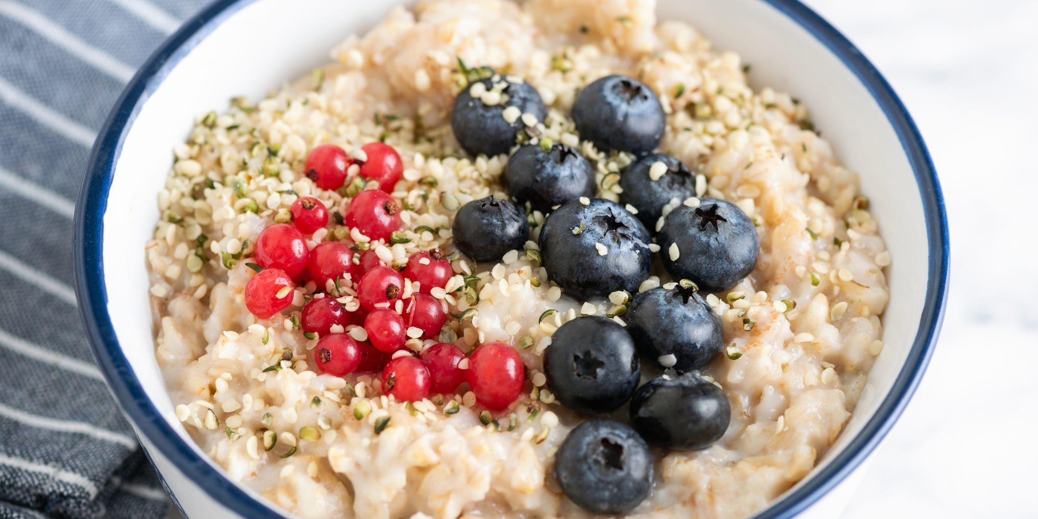 Oatmeal in a bowl topped with blue and red berries.