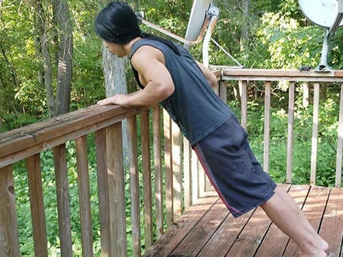 an athlete performing incline pushups on a sturdy railing