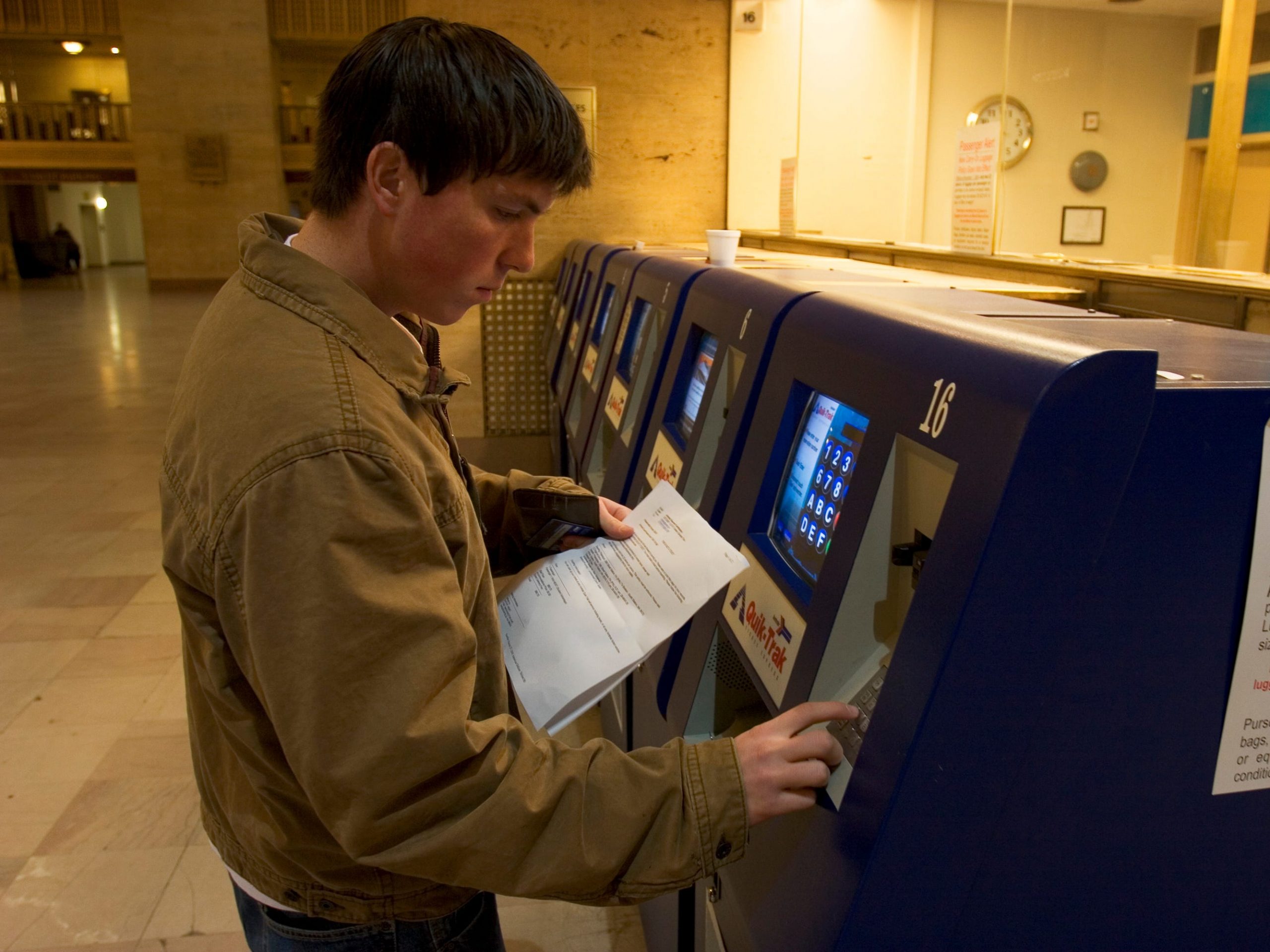 a man purchasing amtrak tickets at a kiosk