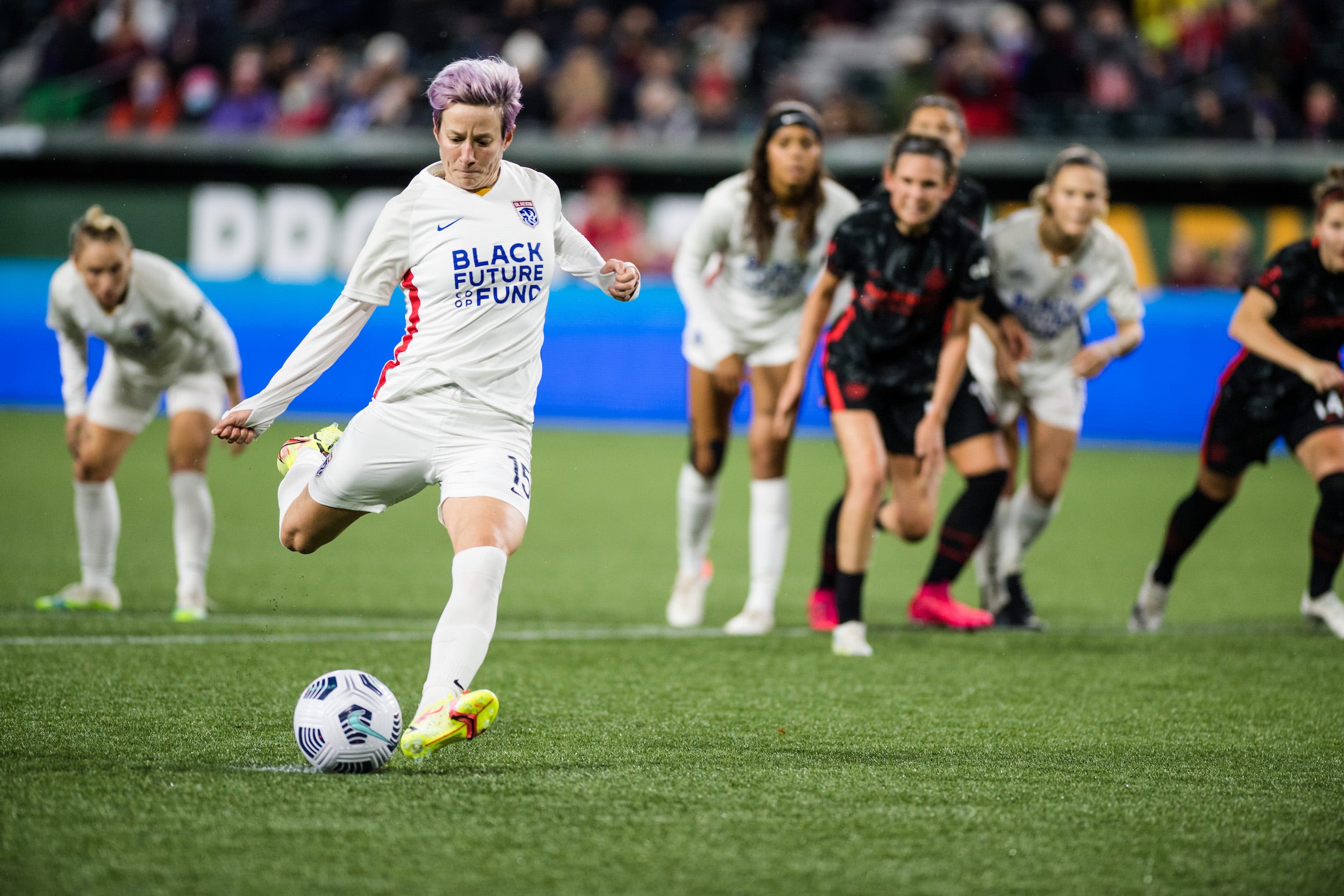 Megan Rapinoe takes a penalty kick for OL Reign during a 2021 NWSL regular-season game against the Portland Thorns.