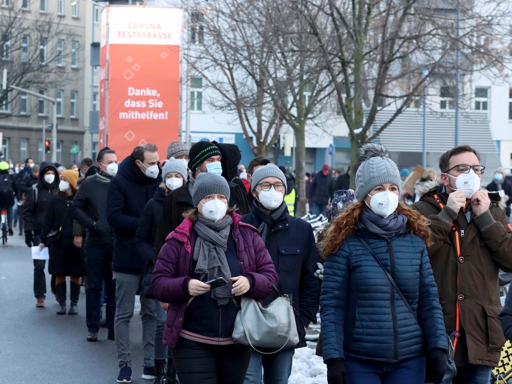 People wearing masks queue in Austria