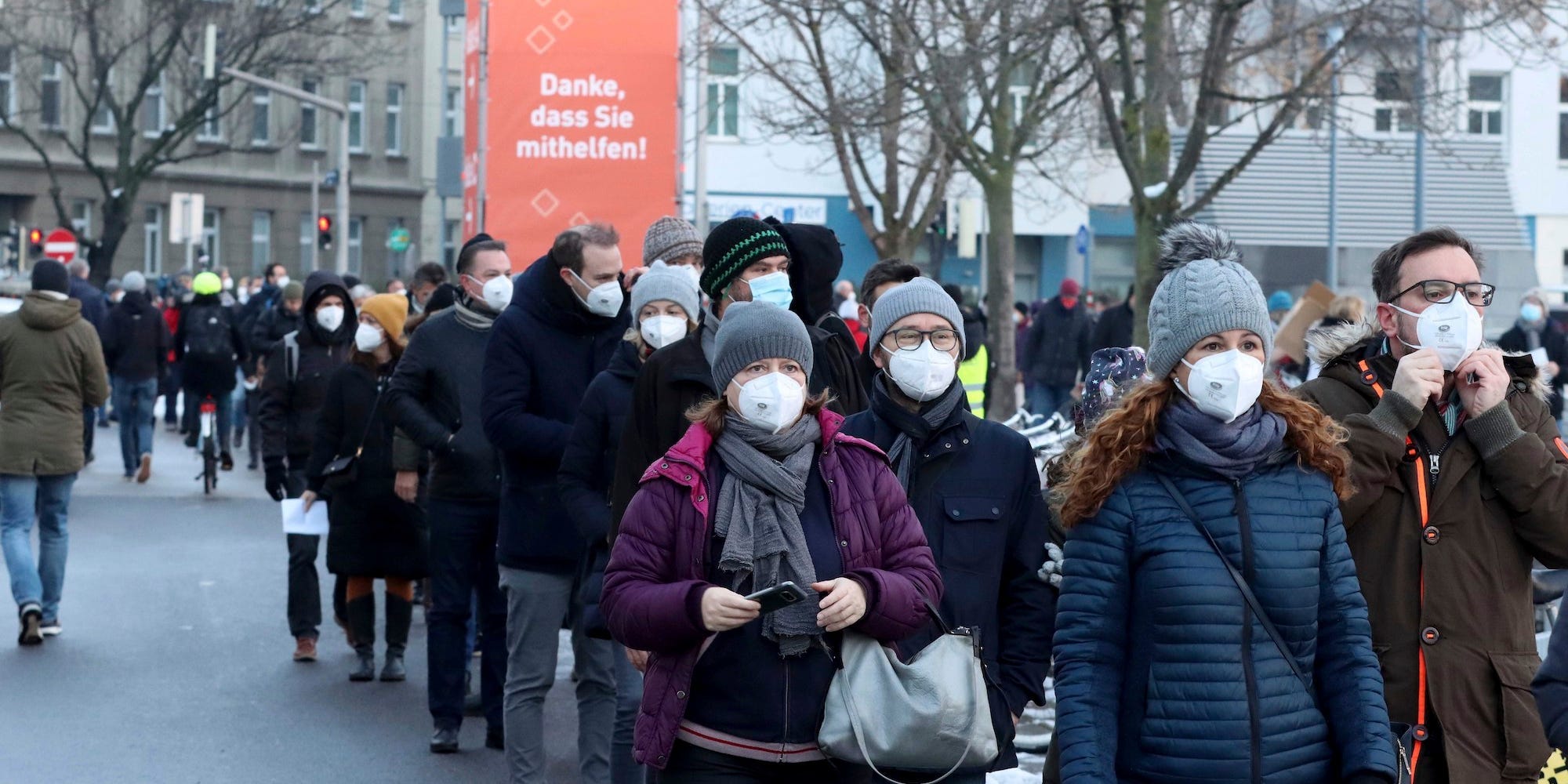 People wearing masks queue in Austria