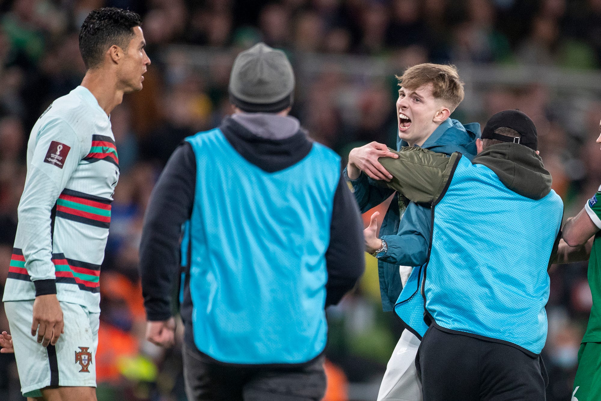 A spectator invades the field of play to confront Cristiano Ronaldo #7 of Portugal as stewards tackle the situation during the Republic of Ireland V Portugal FiFA World Cup European qualifying match at Aviva Stadium on November 11th, 2021 in Dublin, Ireland