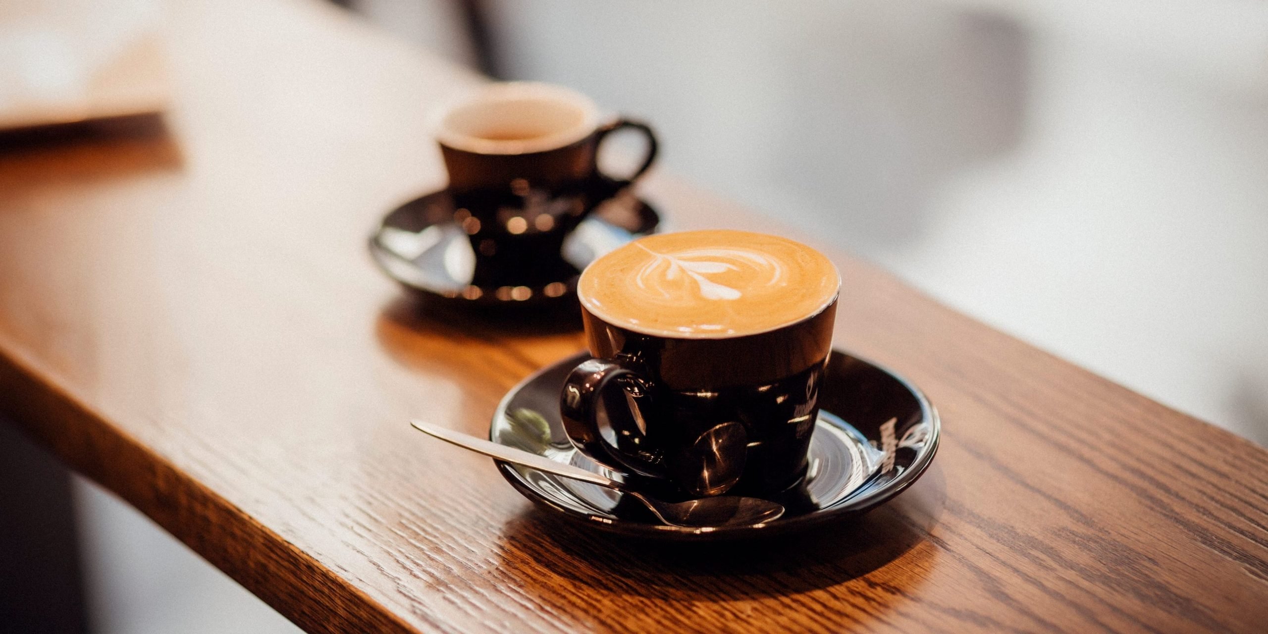 Freshly made Espresso and Latte milk coffee on a timber top