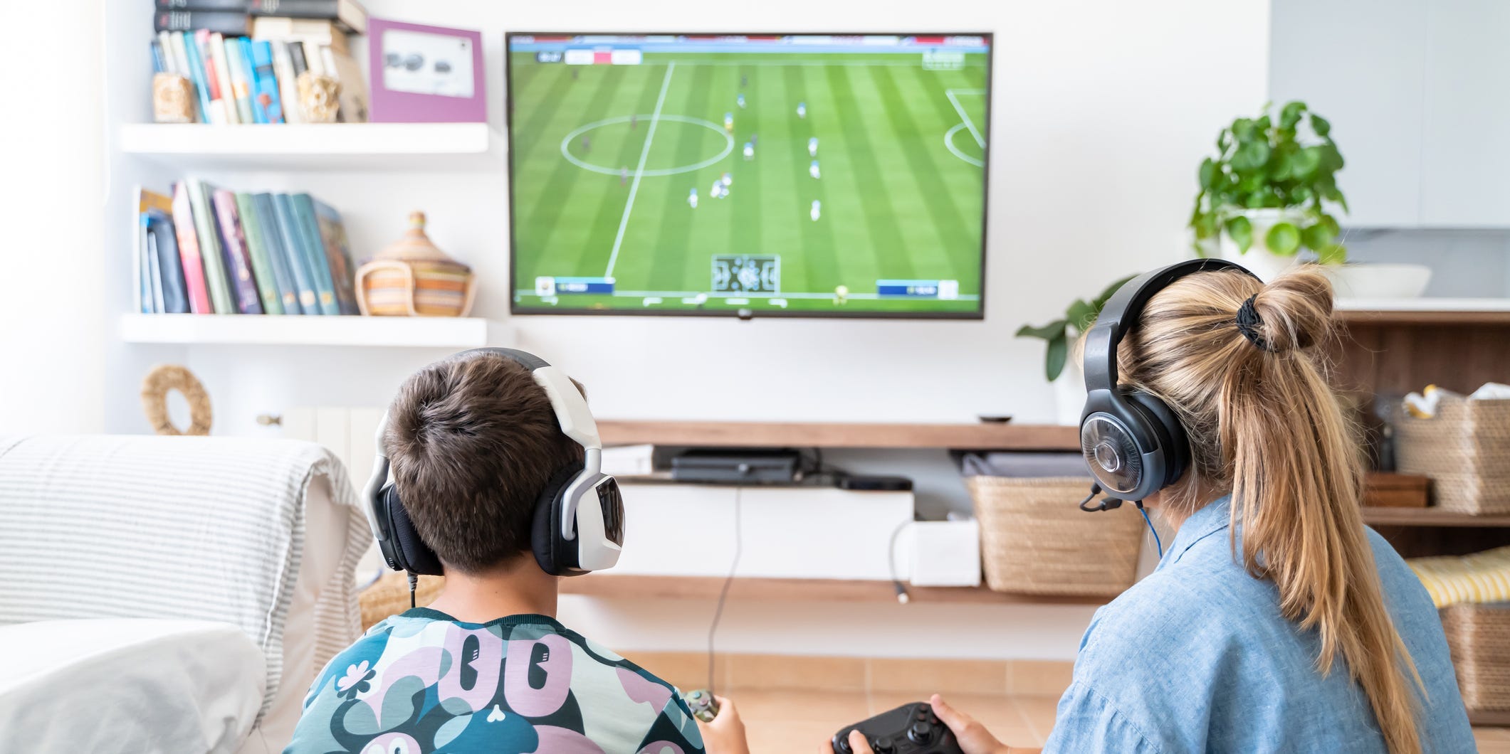 A woman and boy playing a soccer video game on TV