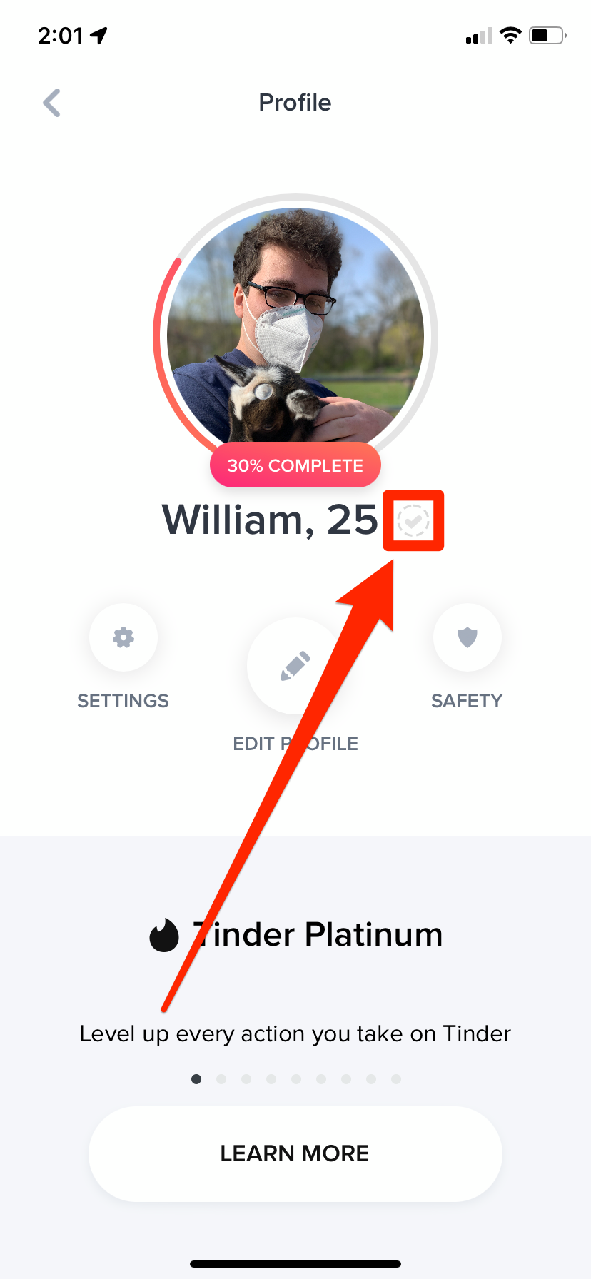 The Tinder profile of an unverified user. The gray checkmark next to their name is highlighted.