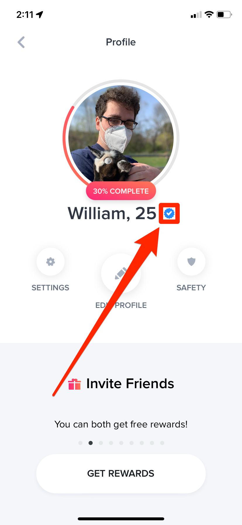 A Tinder user's profile. The blue checkmark next to their name is highlighted.