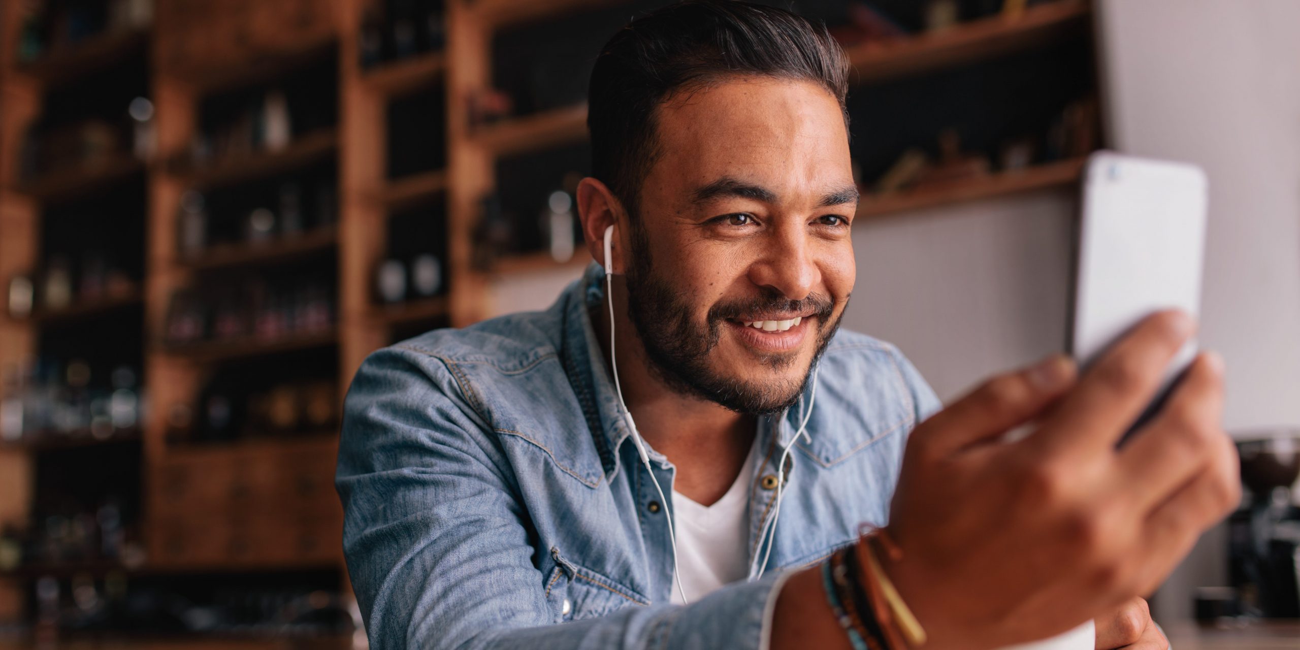 Man taking iphone video in cafe