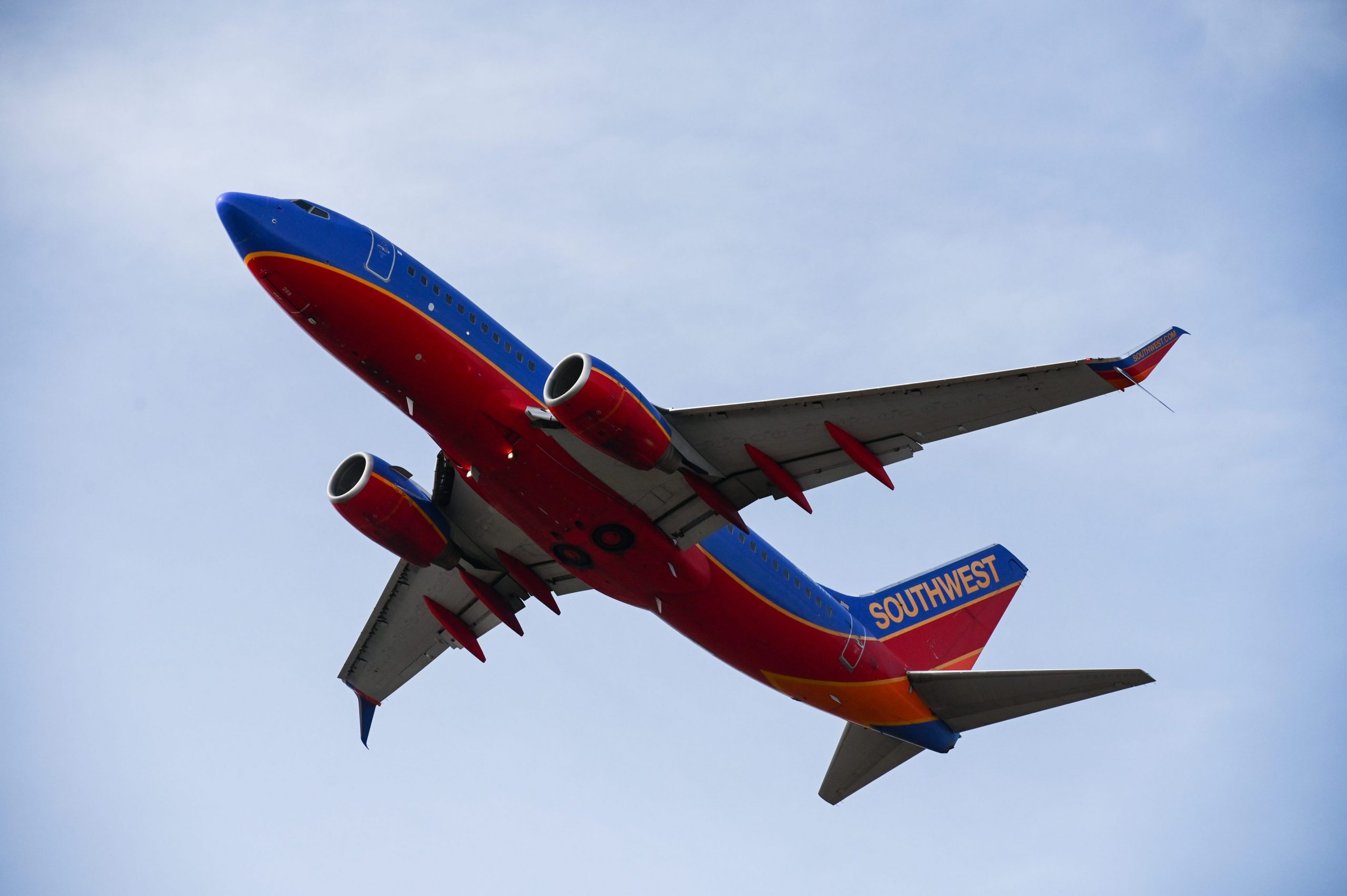 A Southwest Airlines airplane takes off in front of a blue sky