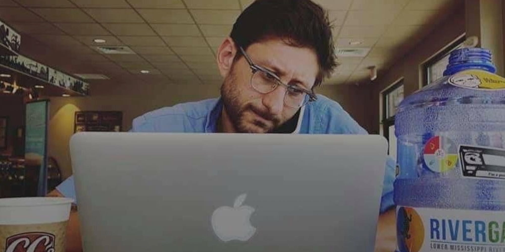 Danny Fenster works on a laptop while also on the phone