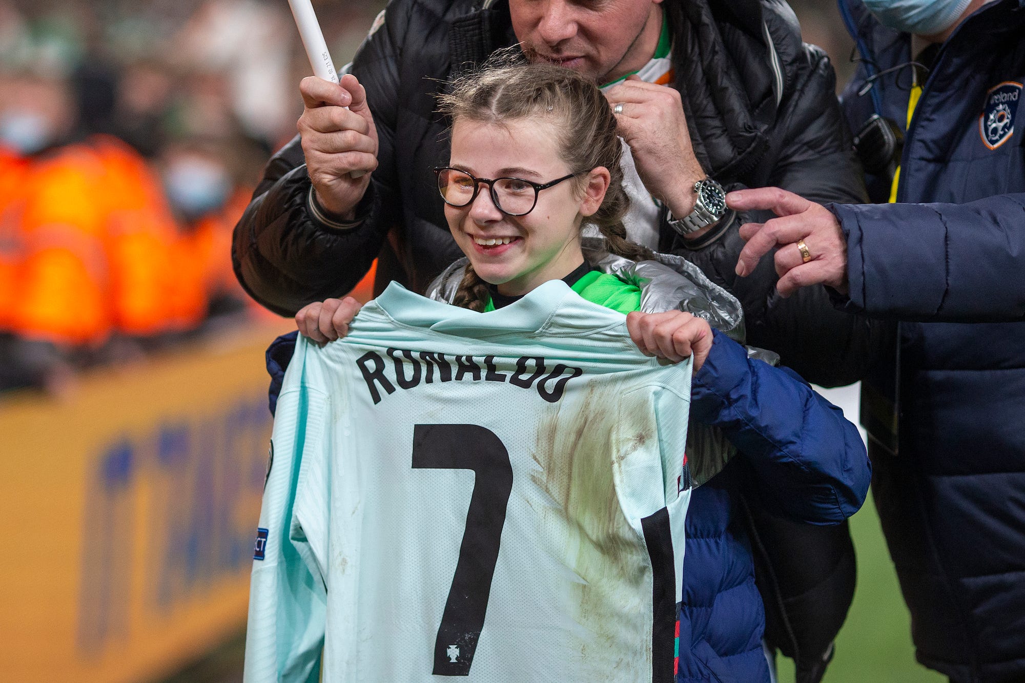 Young fan Addison Whelan, 11, who invaded the pitch at full time, poses for photographs with the shirt of Cristiano Ronaldo #7 of Portugal as she is led from the field after the Republic of Ireland V Portugal FiFA World Cup qualifying match at Aviva Stadium