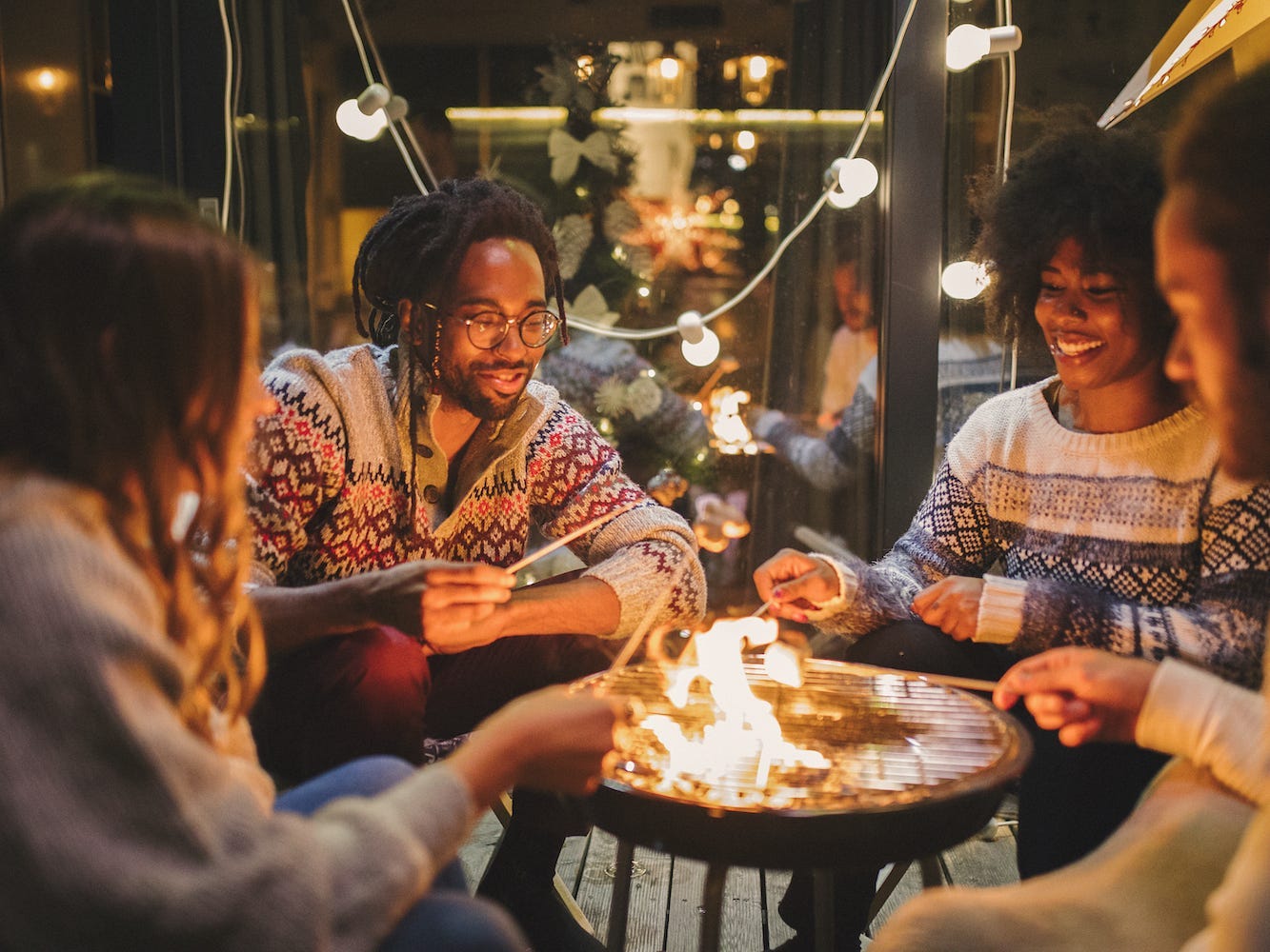 Friends roast marshmallows at a holiday party.