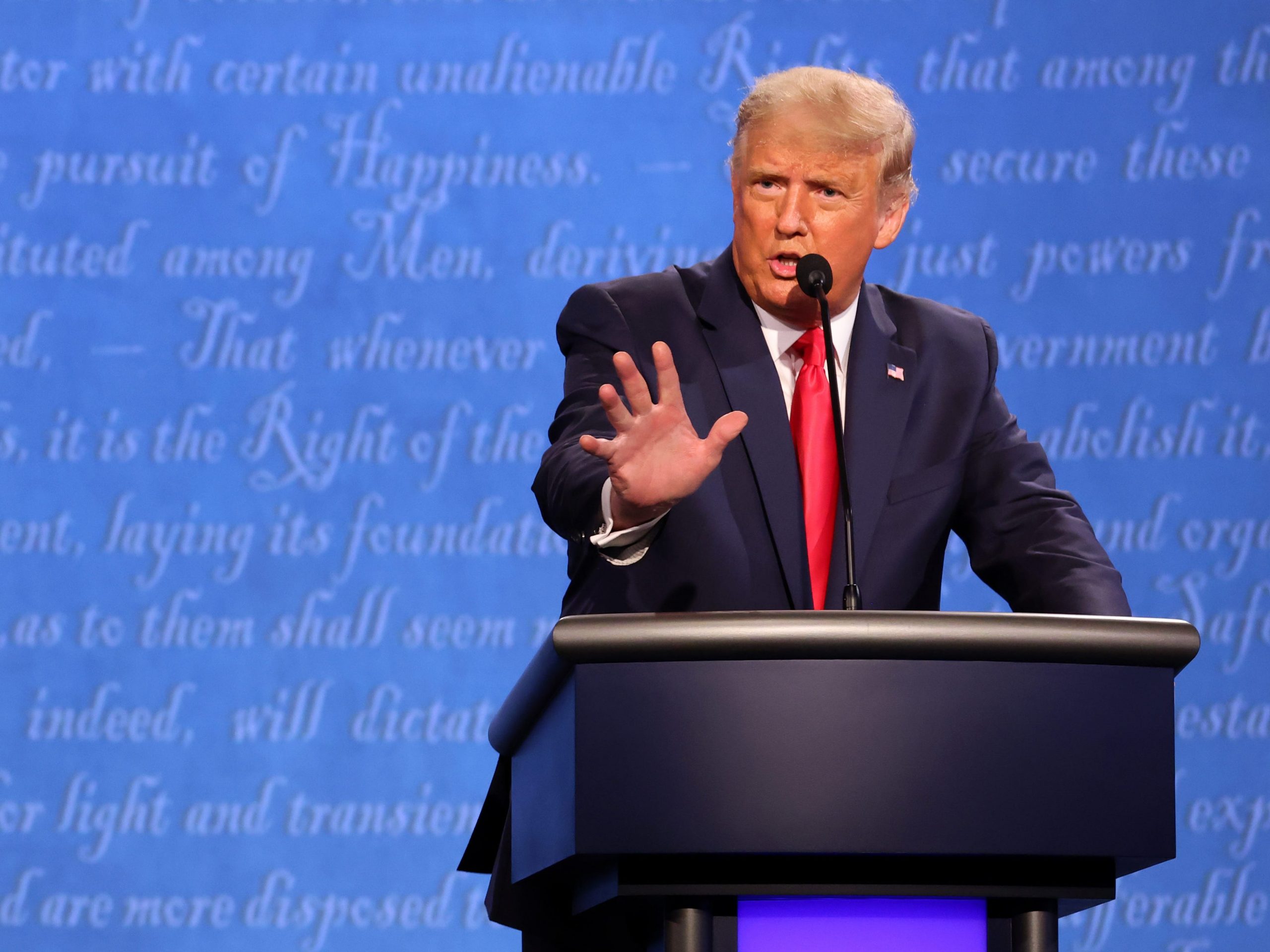 Donald Trump argues during presidential debate against a blue background