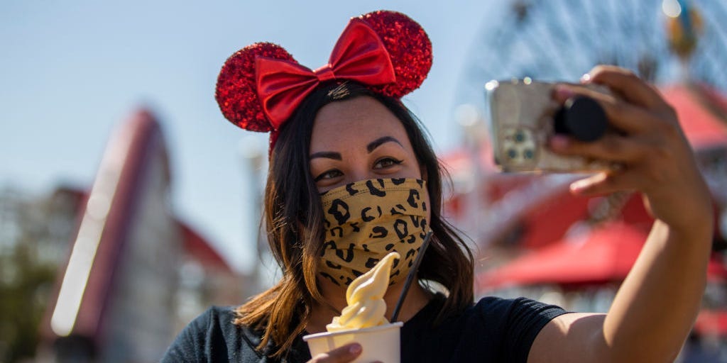 A person at Disney California Adventure park holds up a cup of the Dole whip dessert.