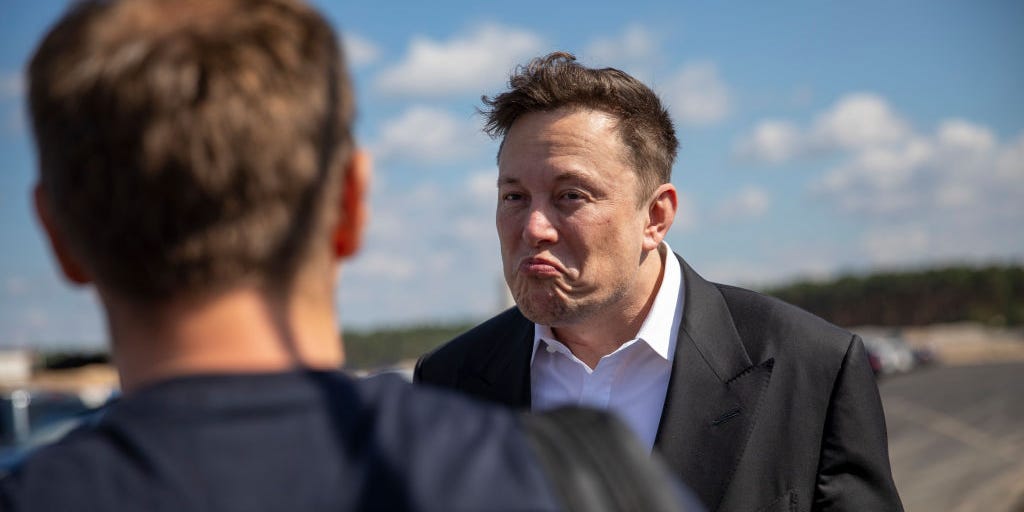 Tesla head Elon Musk talks to one visitor as he arrives to to have a look at the construction site of the new Tesla Gigafactory near Berlin