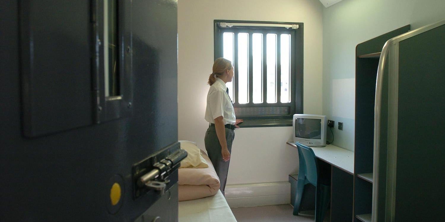 woman guard standing in prison cell HMP Bronzefield