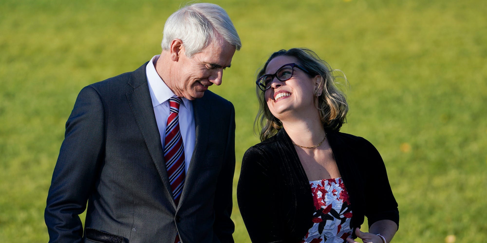 Sen. Kyrsten Sinema, D-Ariz., and Sen. Rob Portman, R-Ohio, talk before President Joe Biden signs the $1.2 trillion bipartisan infrastructure bill into law during a ceremony on the South Lawn of the White House in Washington, Monday, Nov. 15, 2021.