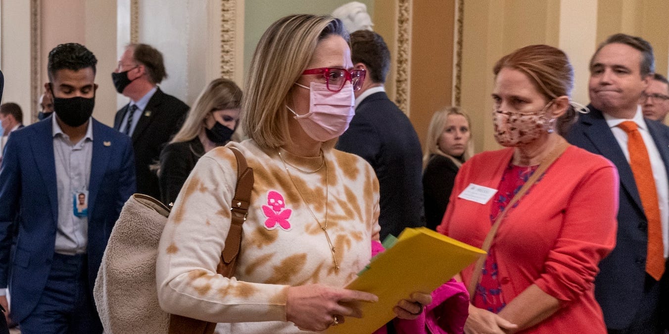 Sen. Joe Manchin, D-W.Va., left, walks with Sen. Kyrsten Sinema, D-Ariz., after attending a Democratic policy luncheon, Tuesday, Nov. 16, 2021, on Capitol Hill in Washington