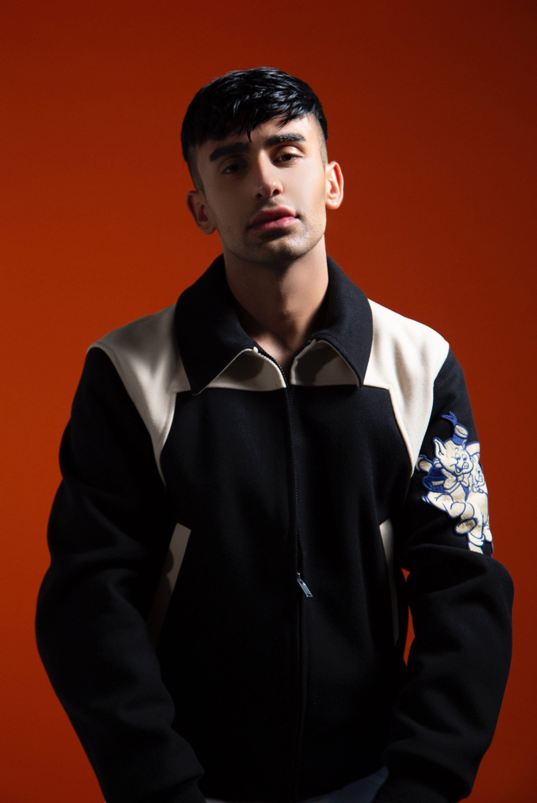 Close up of man in black and white jacket looking at the camera