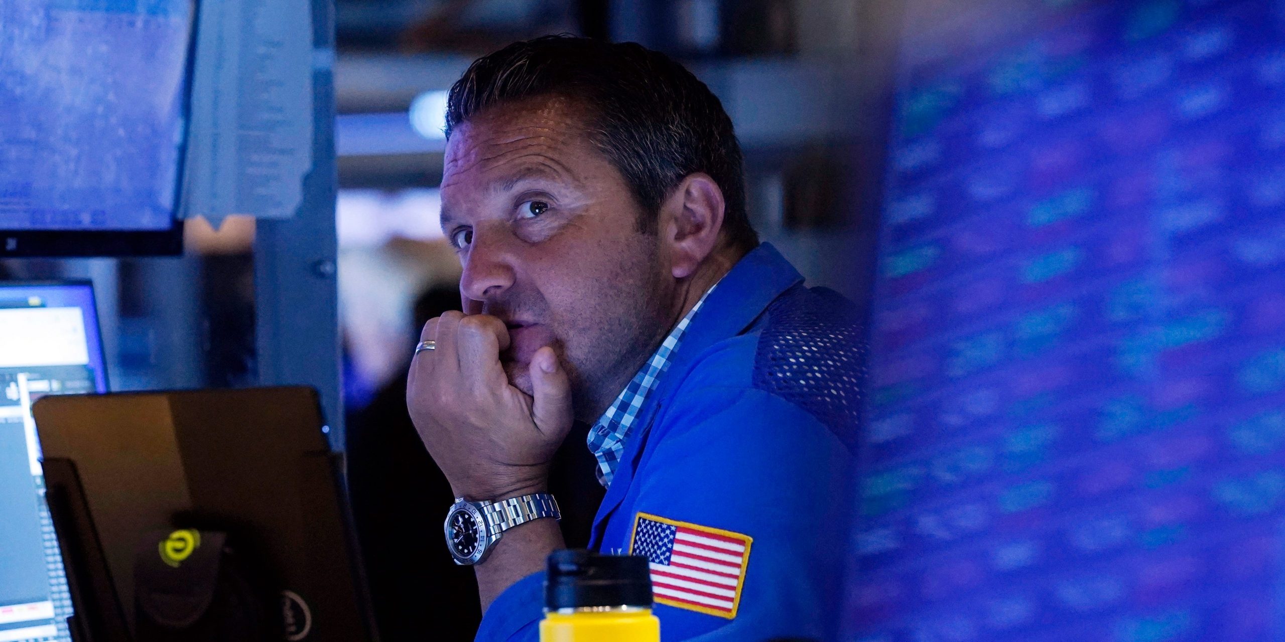 A trader sits in front of a computer monitor on the floor of the New York Stock Exchange.