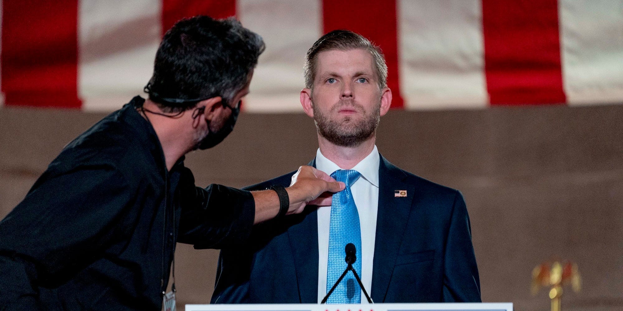 Eric Trump, the son of President Donald Trump, has his tie adjusted before taping his speech for the second day of the Republican National Convention from the Andrew W. Mellon Auditorium in Washington, Tuesday, Aug. 25, 2020.